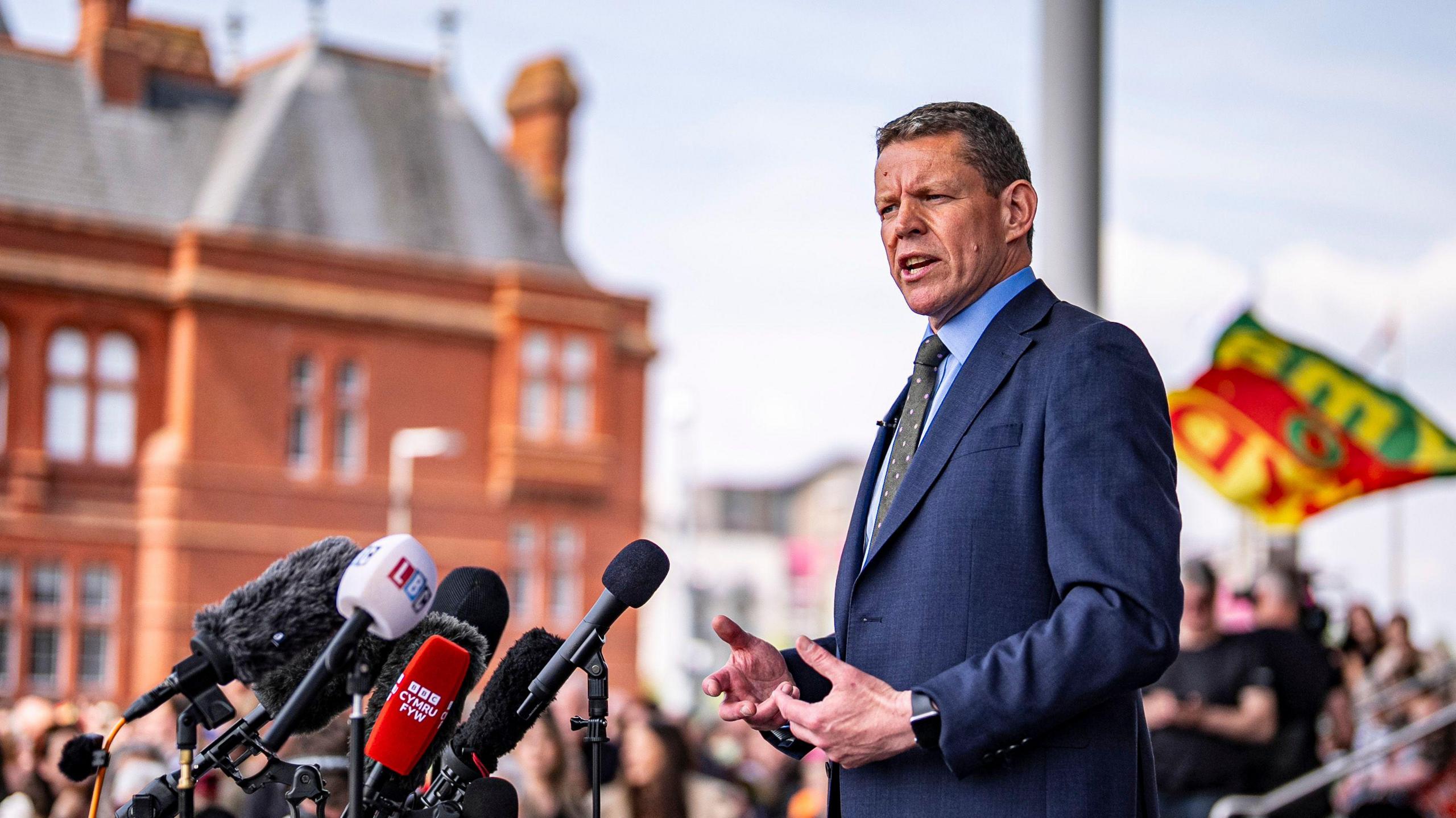 Rhun ap Iorwerth speaking at a news event outside the Senedd.