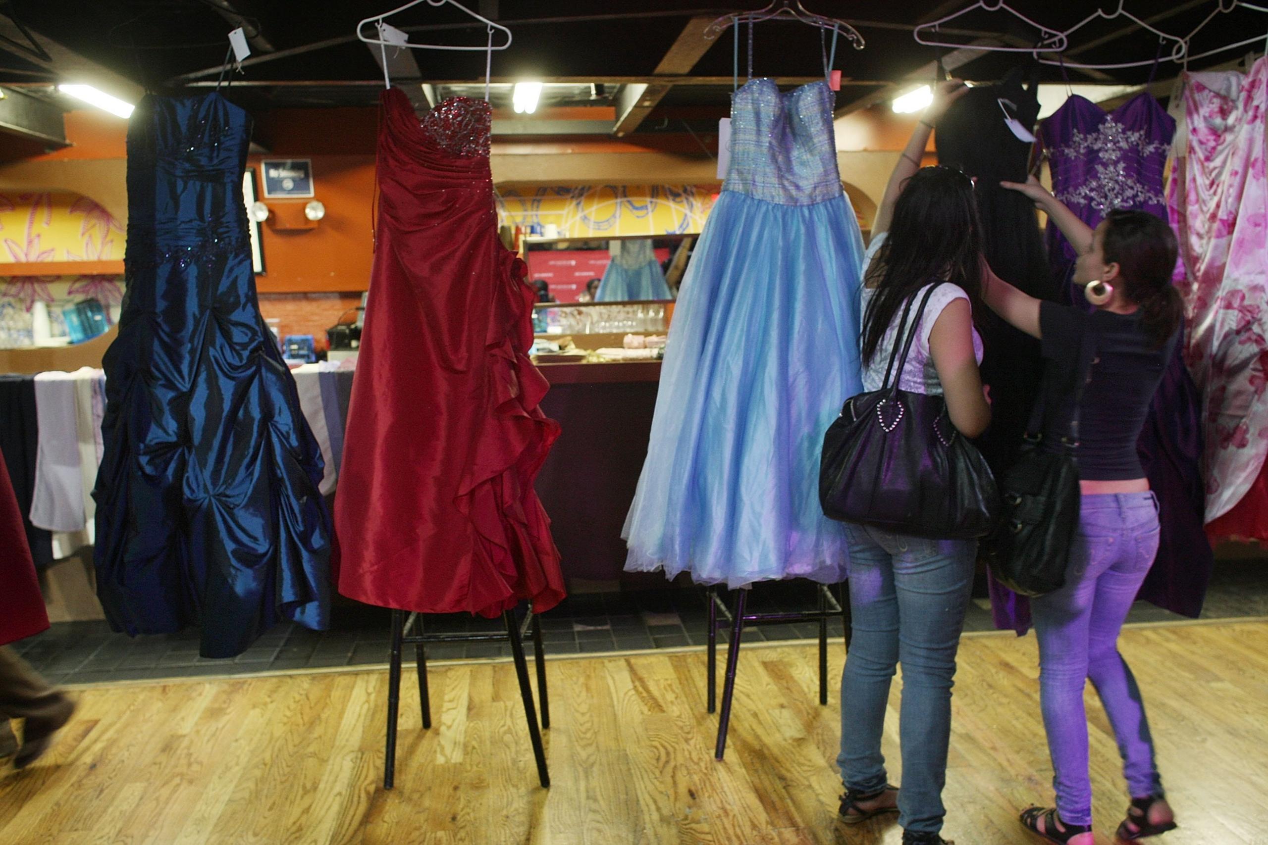 Women look at prom dresses at Project Prom, an event offering free dresses, handbags, shoes and accessories to high school students on May 22, 2009 in New York City.