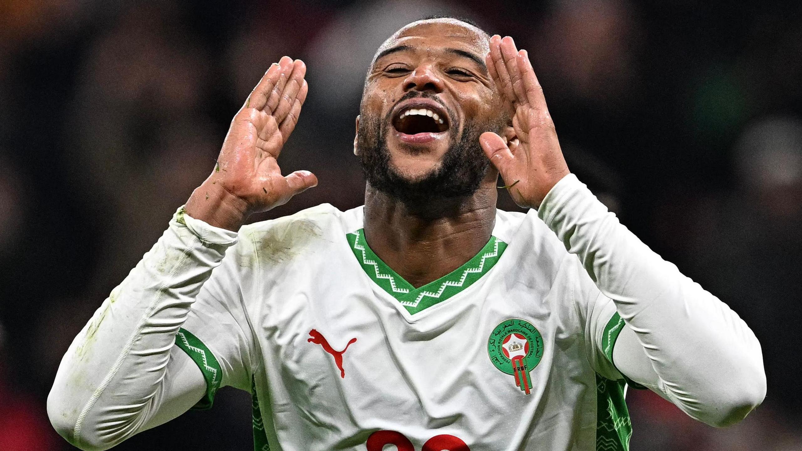 Ayoub El Kaabi holds two hands up towards his face as he shouts in celebration