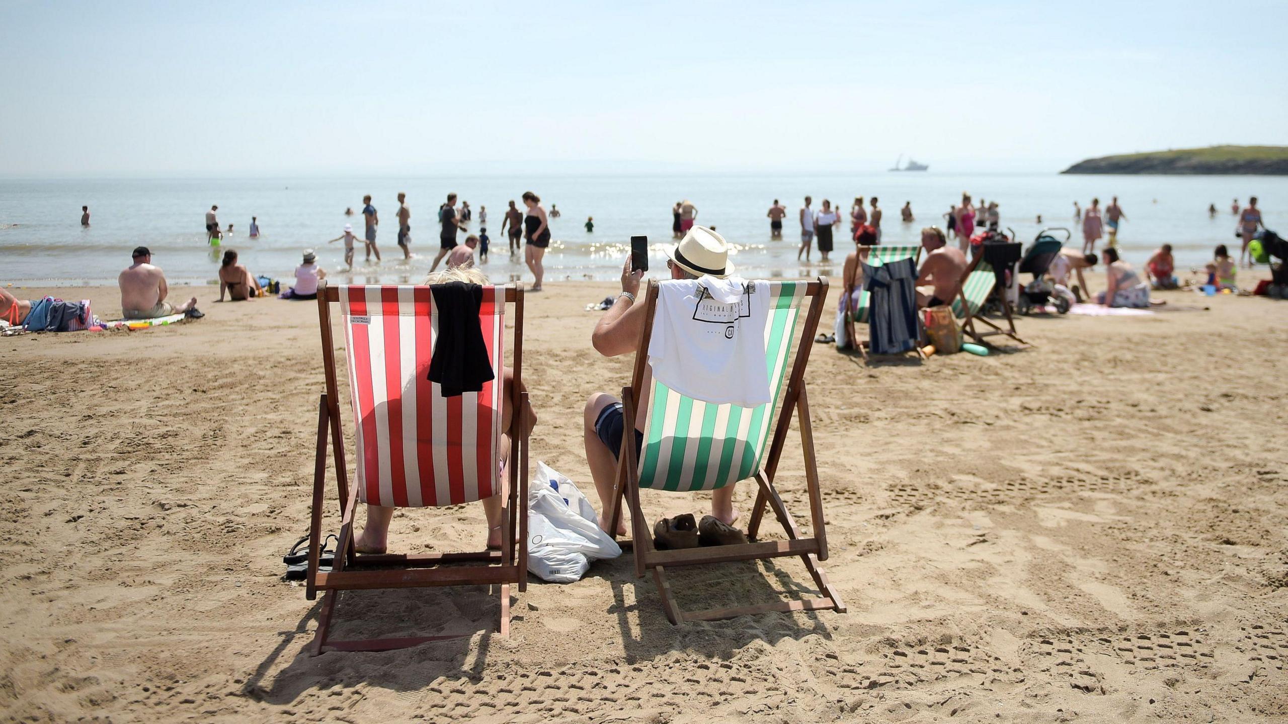 People sunbathing on a sandy beach.