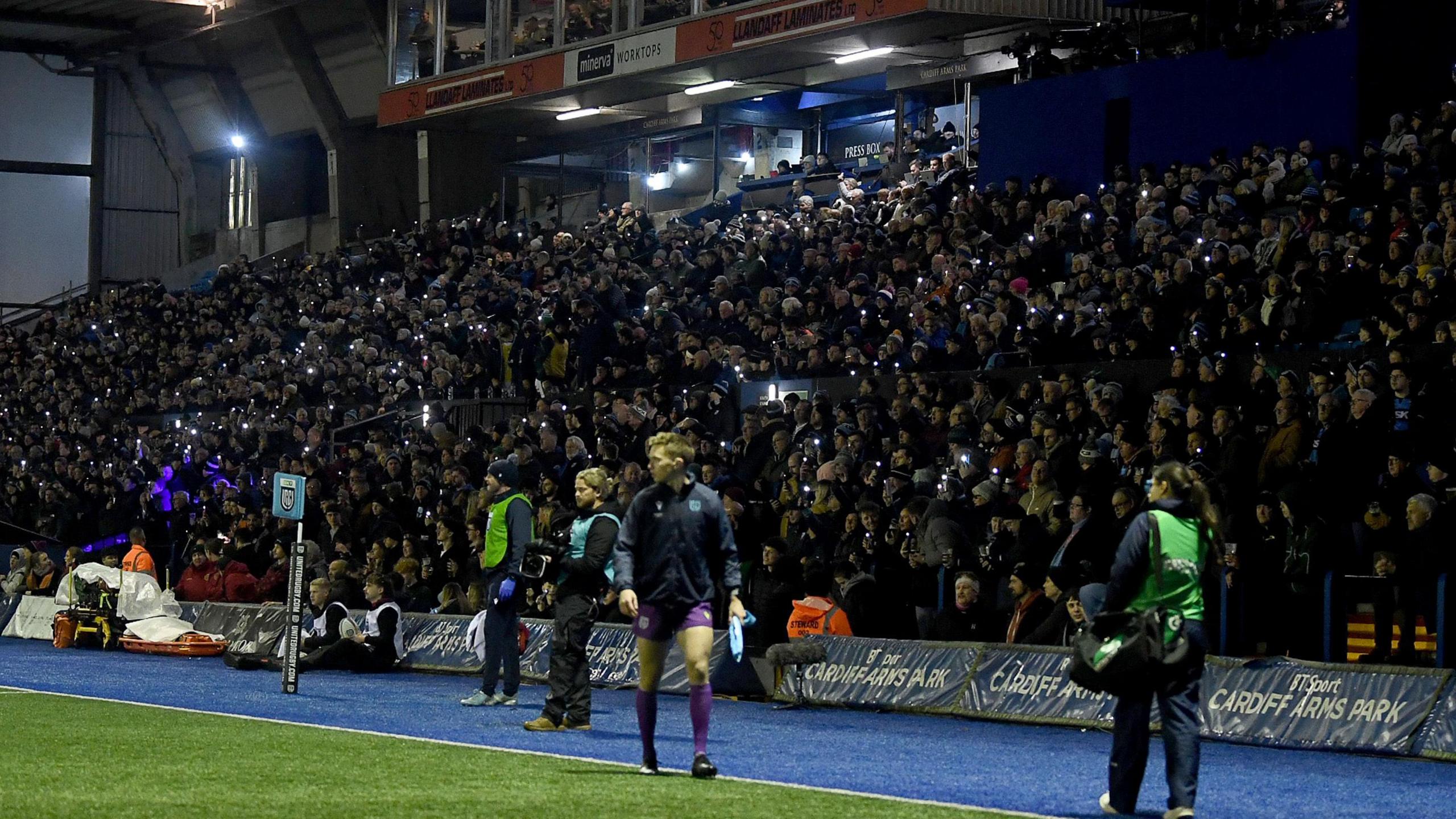 Cardiff fans protesting against the WRU plans to sell the club to Ospreys owners Y11 Sport and Media by putting their camera phone on after 11 minutes