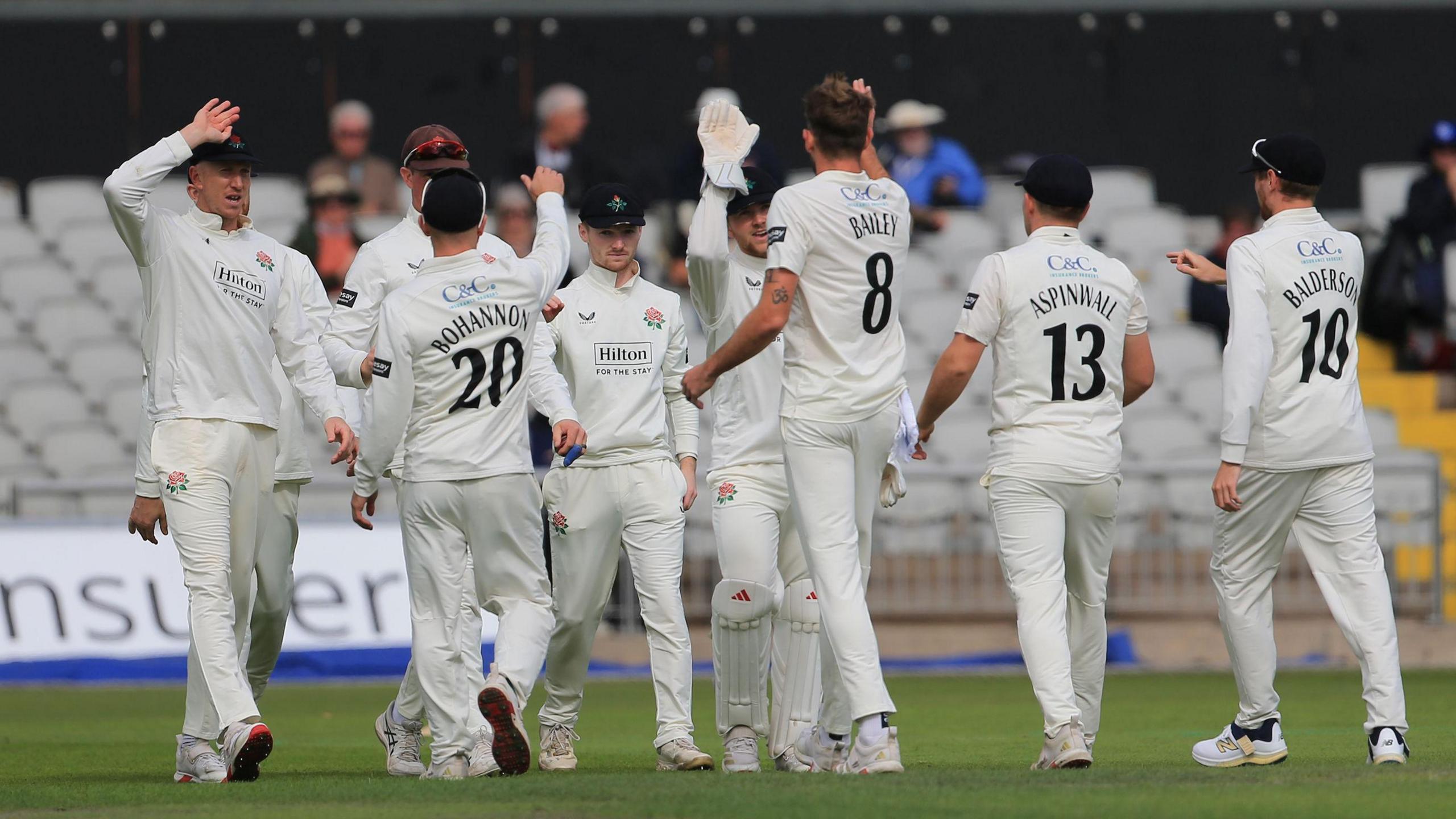 Lancashire players gather round Tom Bailey to celebrate his first of four Middlesex wickets 