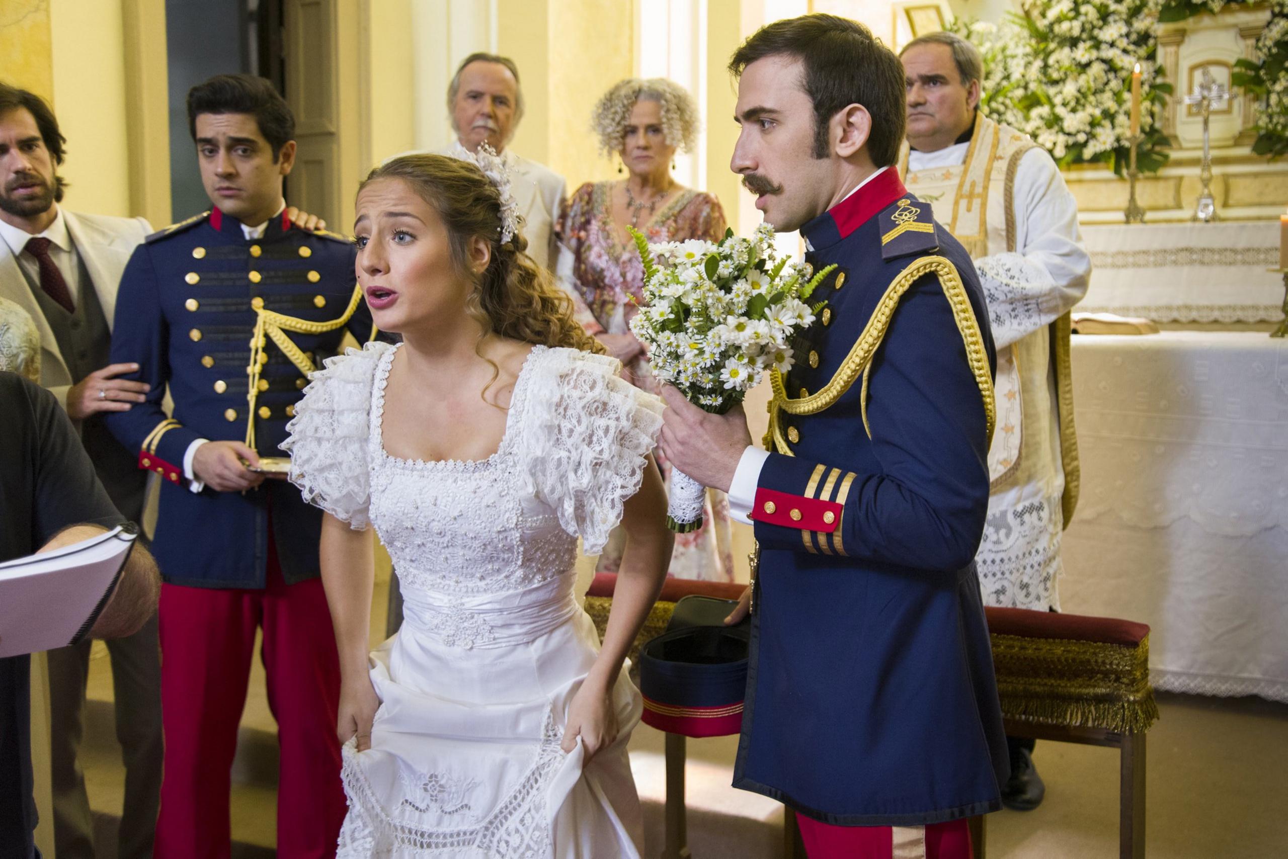 Lídia Benedito, played by Bruna Griphão, gets ready to do a runner as Otávio. played by Pedro Henrique Muller, looks aghast