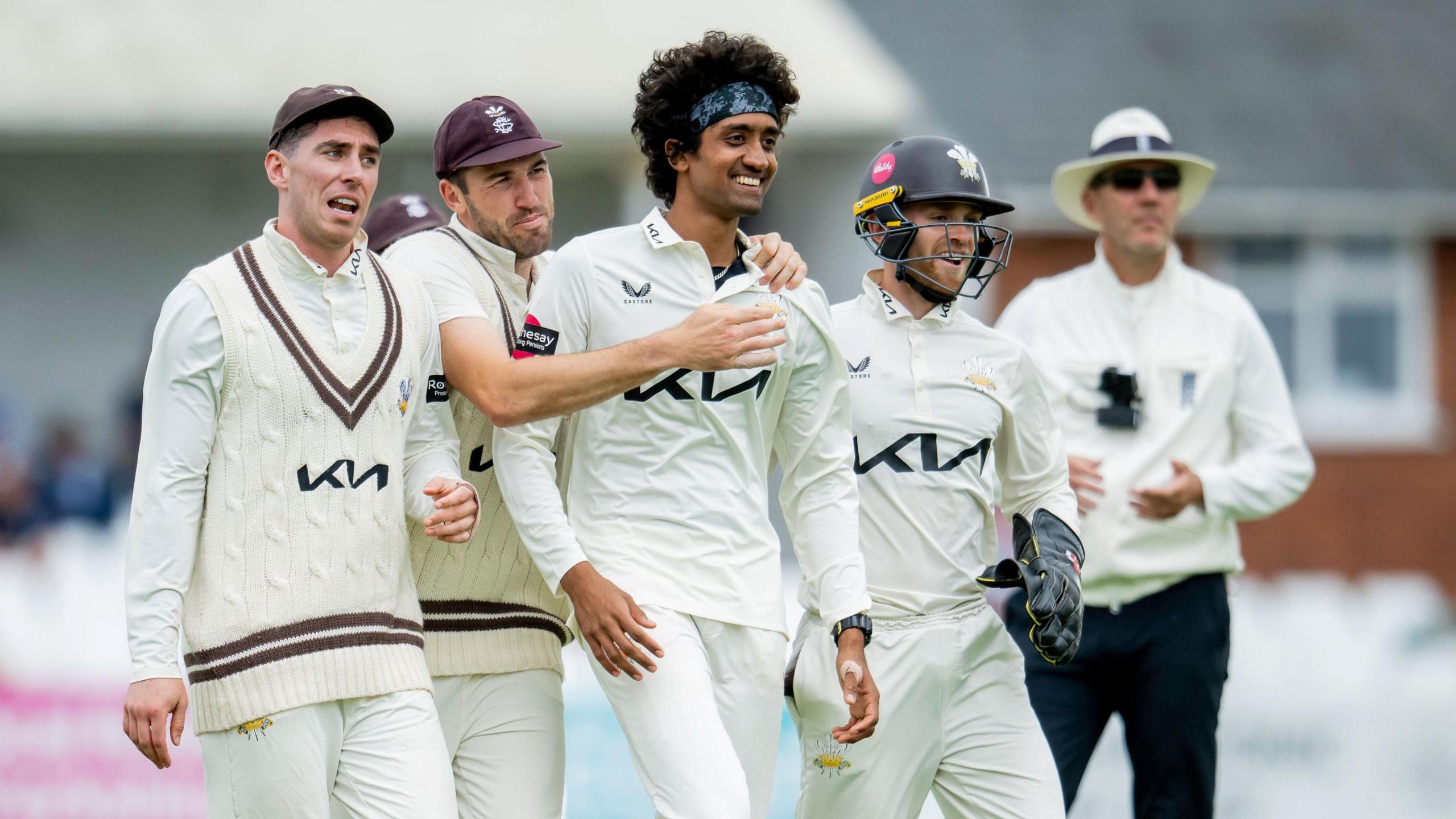 Surrey players congratulate each other after taking a wicket