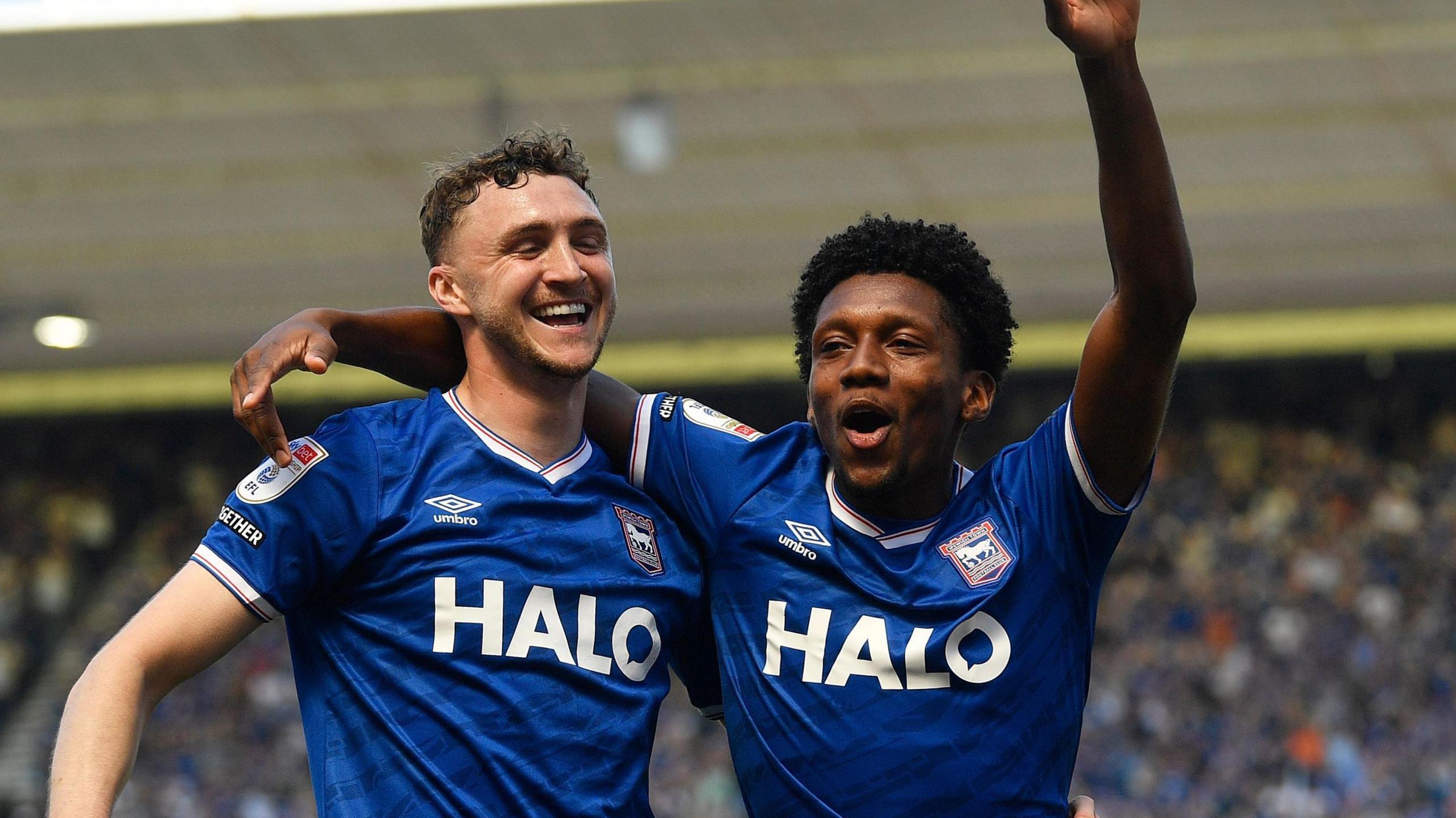 Jack Taylor (left) has his arm round Jaden Philogene, who has his left arm aloft, after Philogene scored Ipswich's second goal 