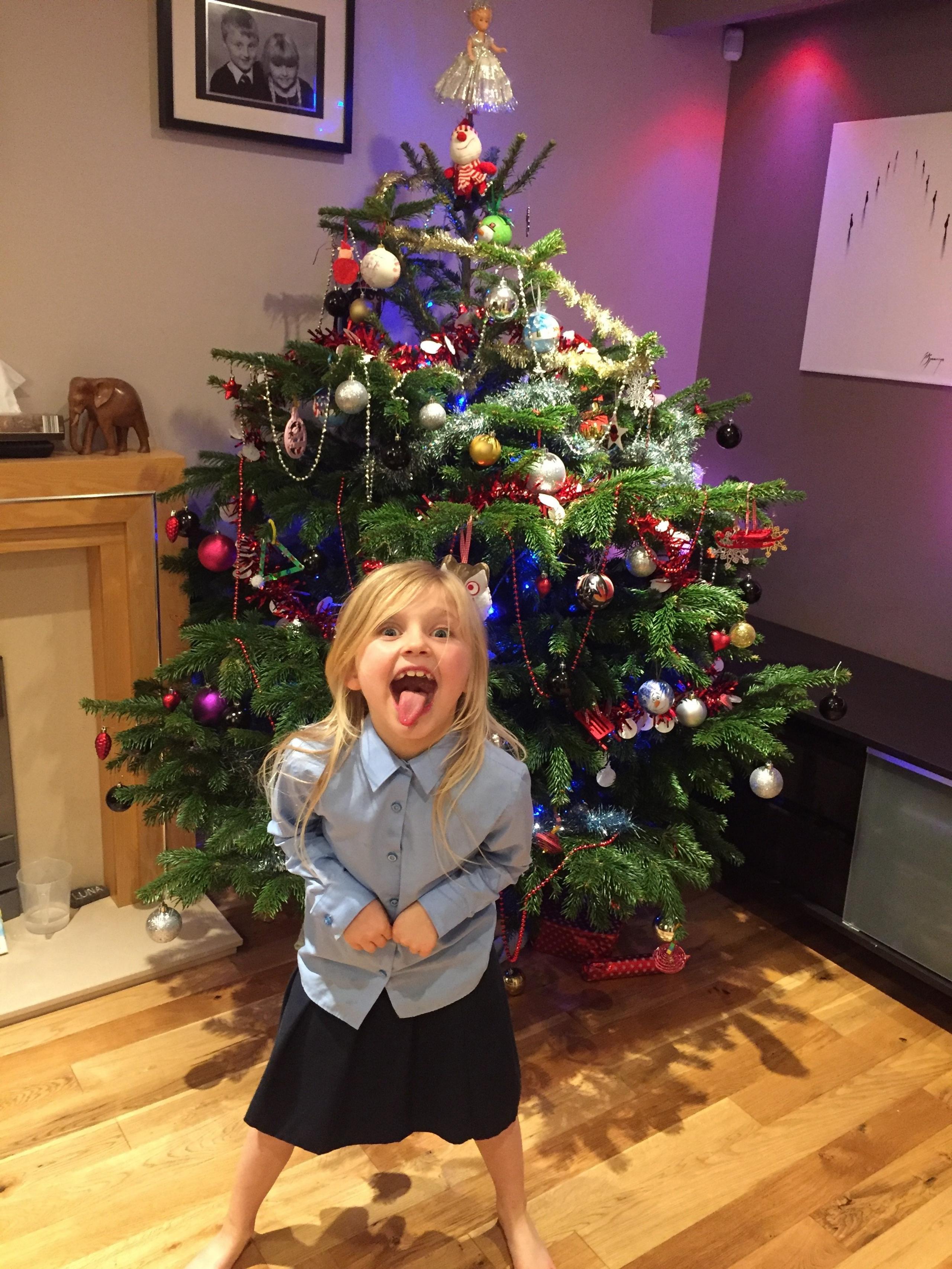 A girl in front of a Christmas tree