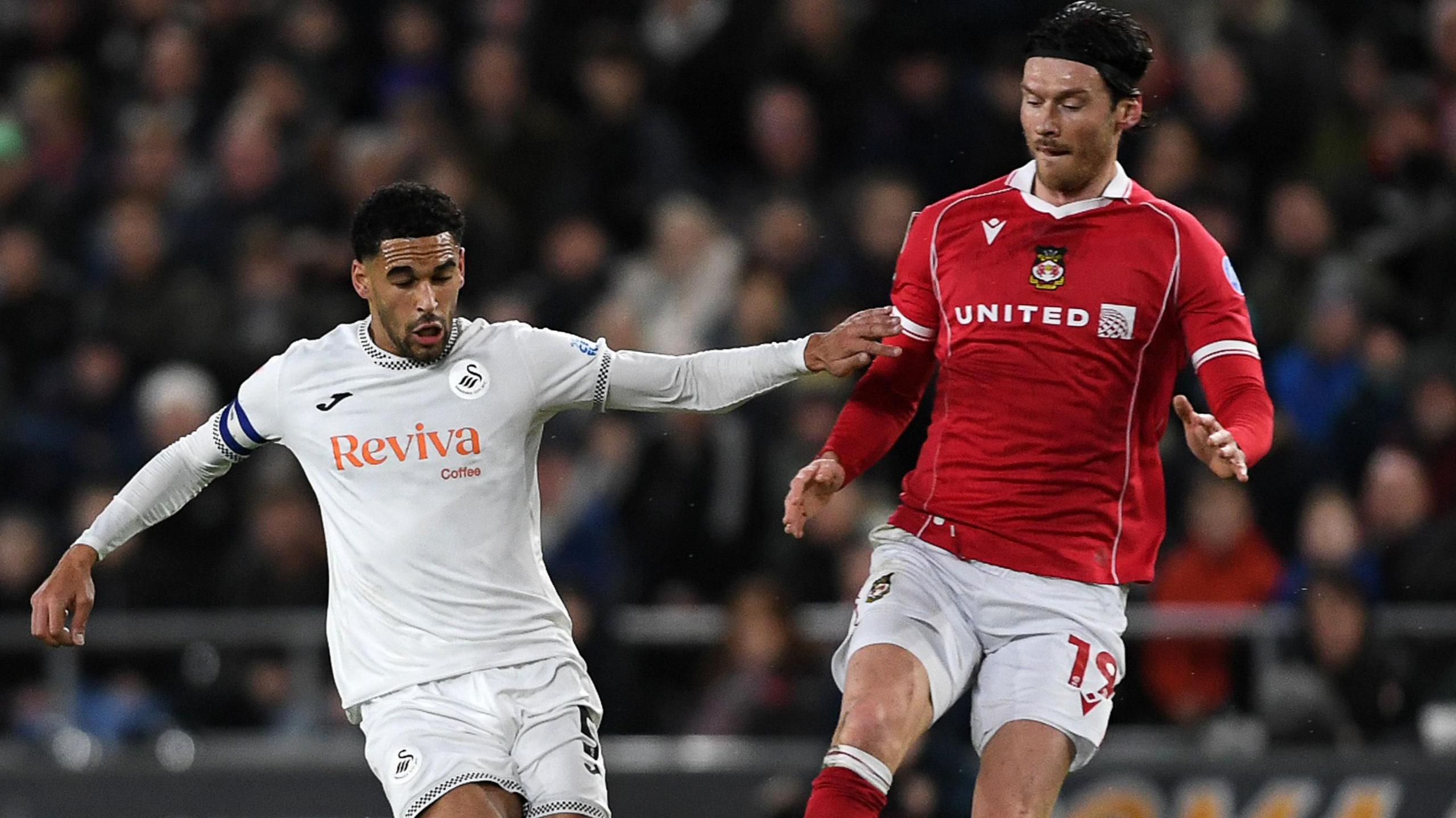Ben Cabango (left) of Swansea challenges Wrexham's Kieffer Moore