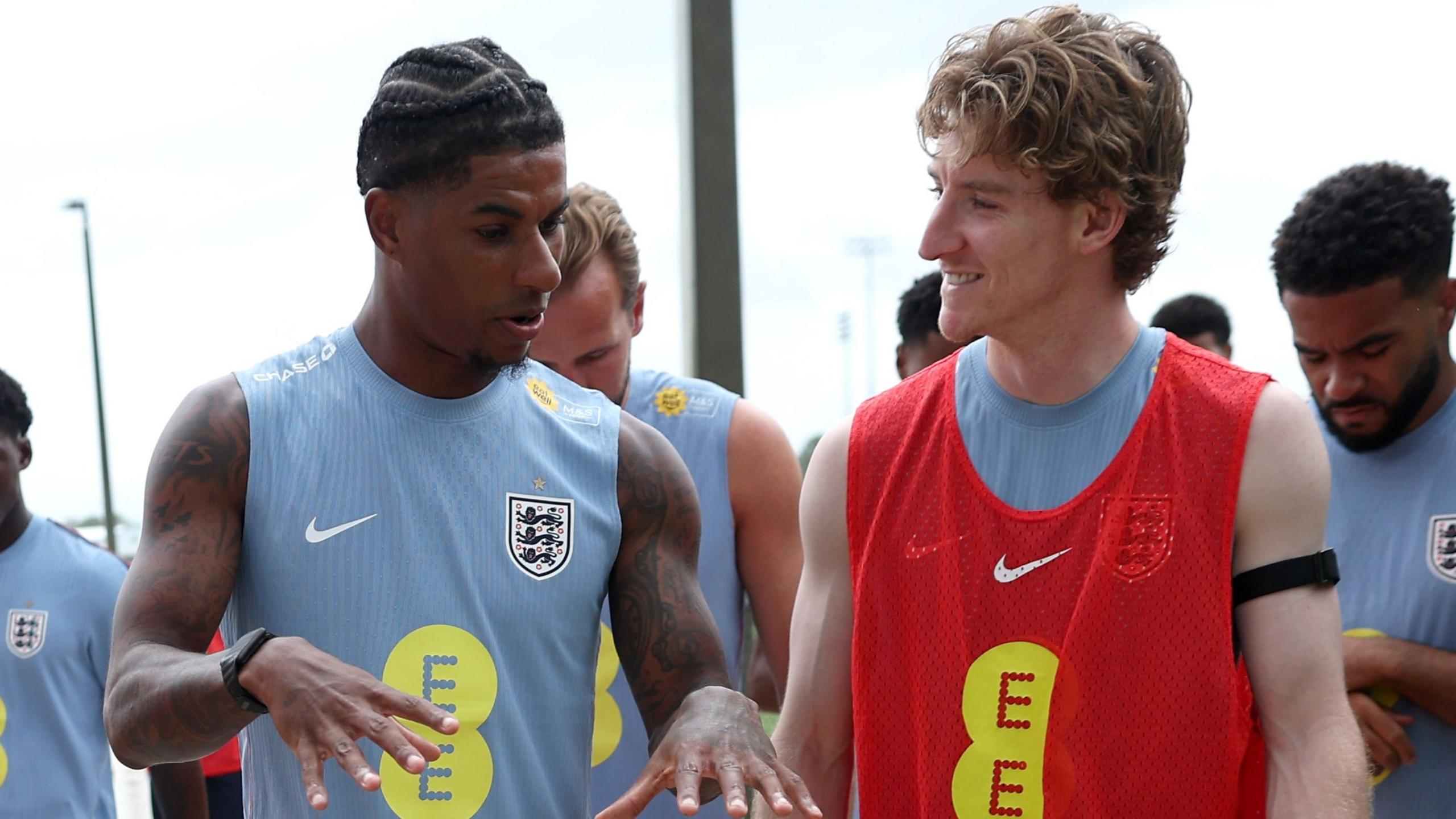 Marcus Rashford and Anthony Gordon of England interact as they walk out for a training session