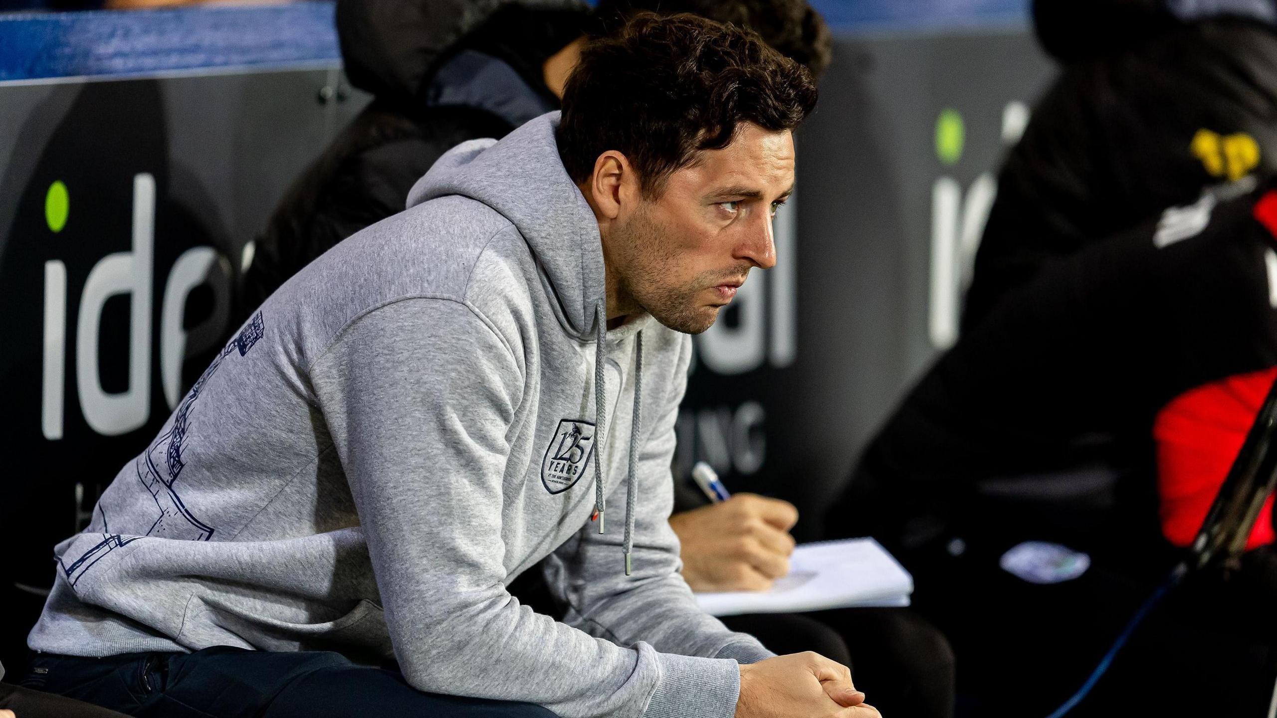 Ryan Mason leans forward in the West Bromwich Albion dugout during a match