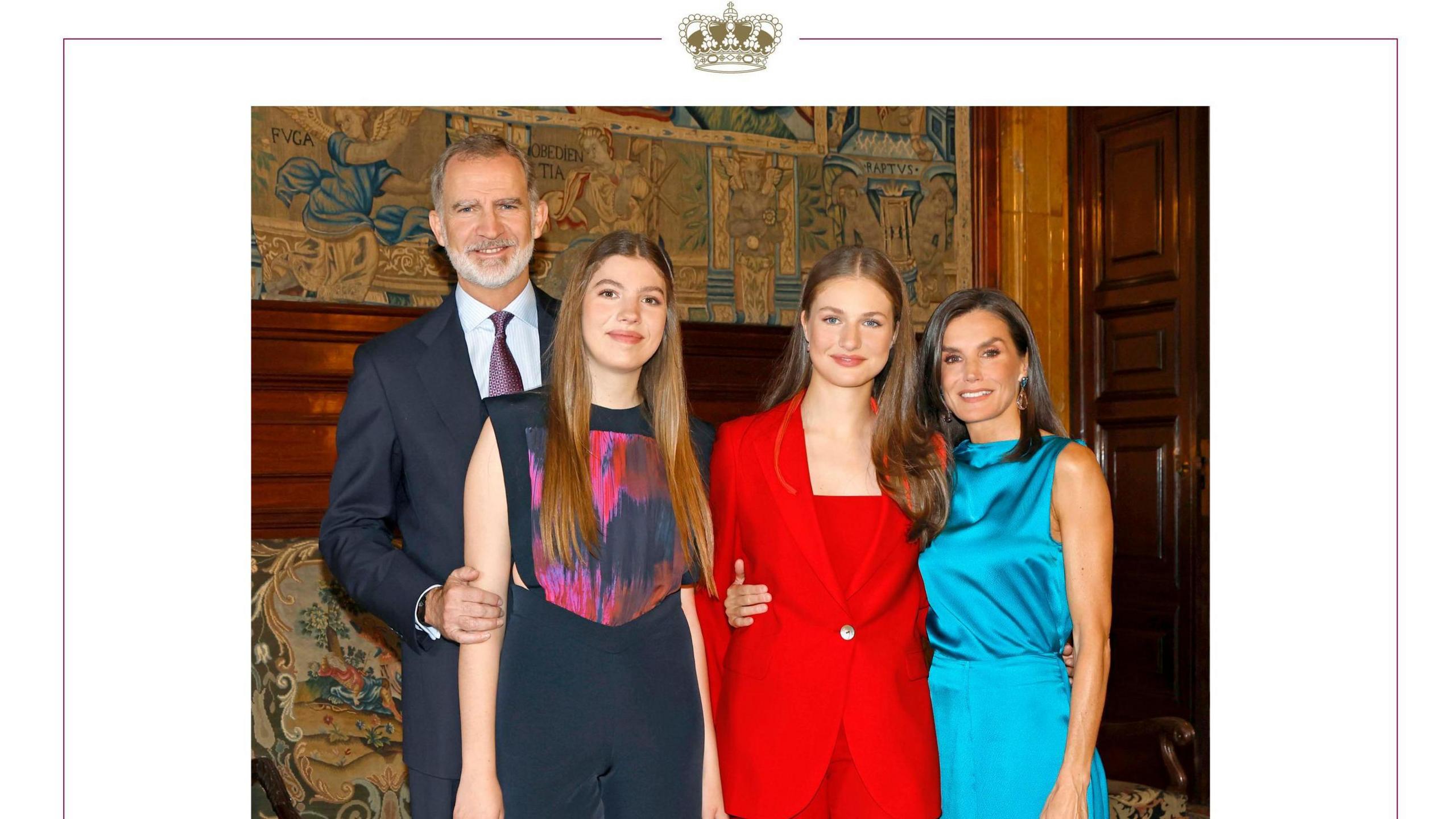 Spanish royal Christmas card for 2024, featuring four figures standing close together, looking directly at the camera, in a grandly decorated room.