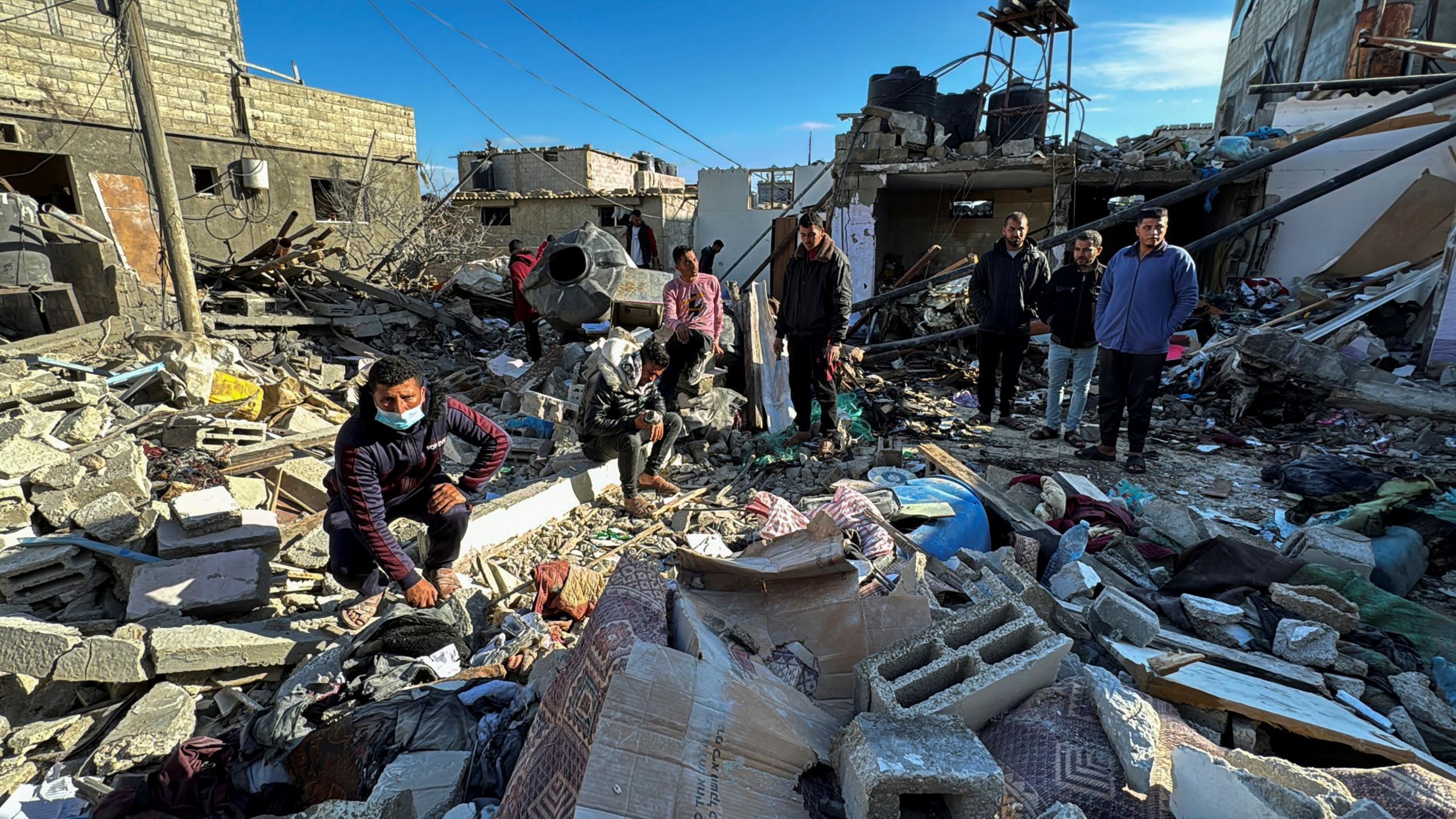 Palestinians inspect the site of an Israeli strike