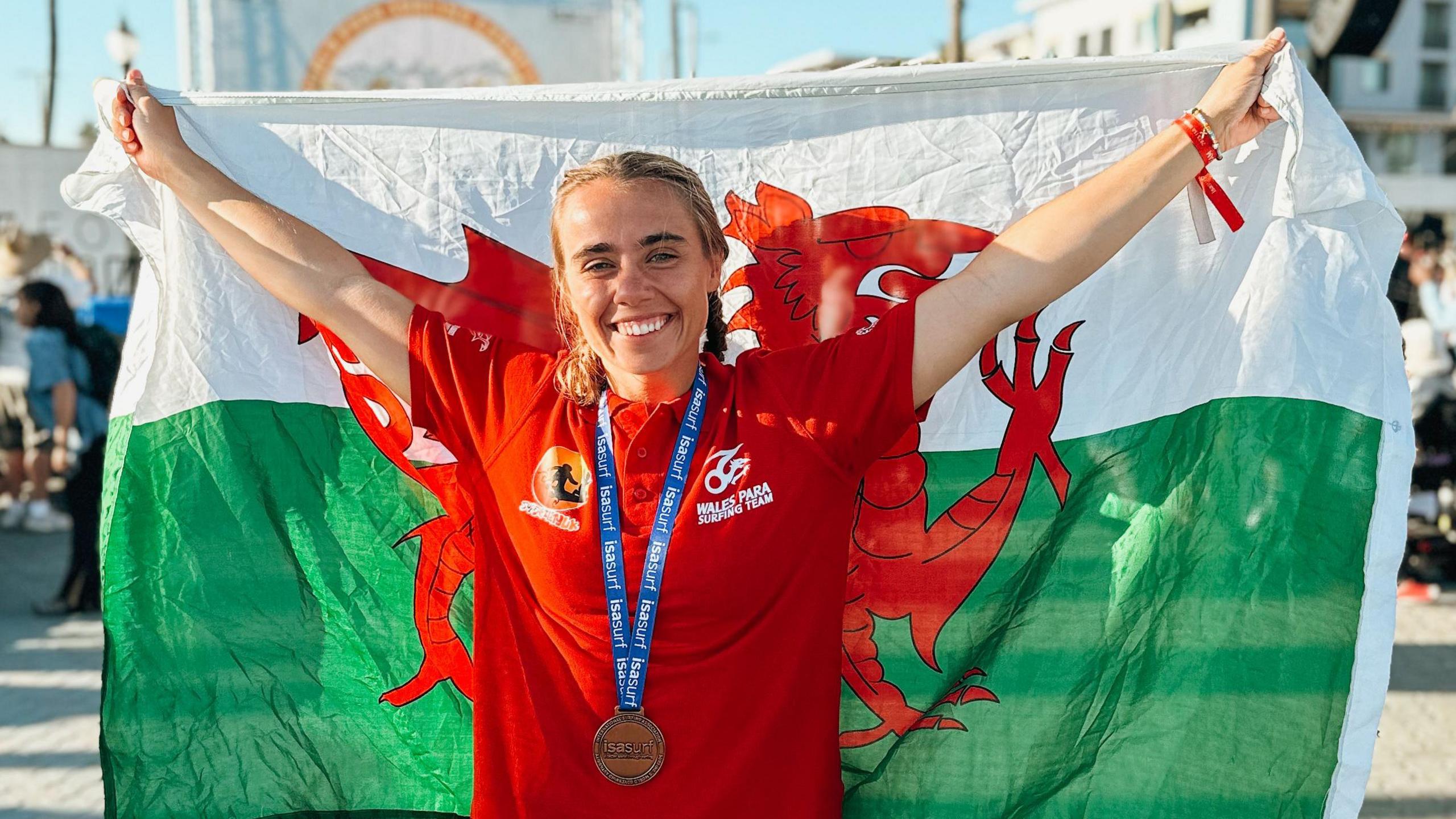 Kirsty Van der Poll poses with Welsh flag during a surfing competition