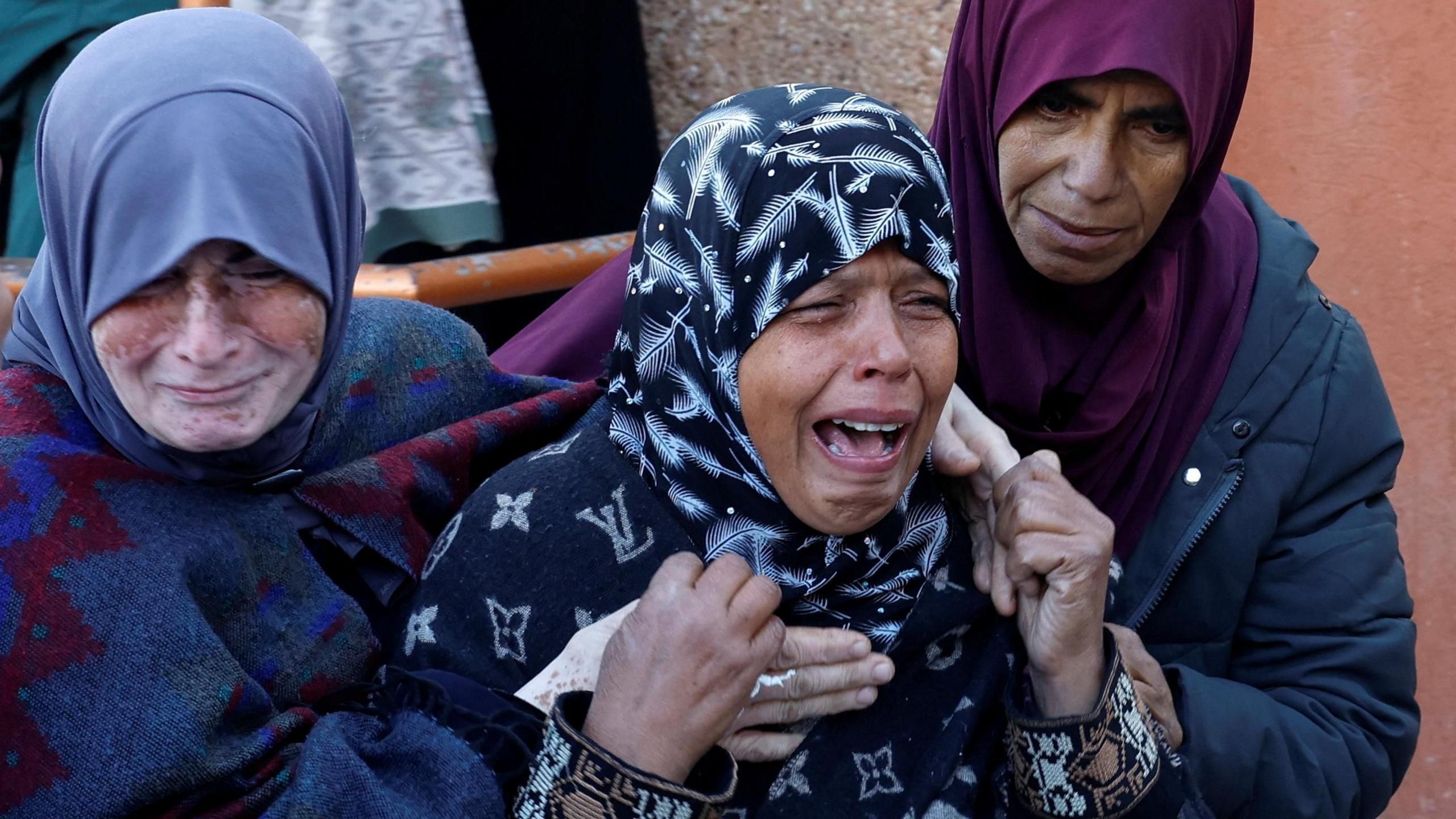 Women mourn during a funeral for Palestinians killed in overnight Israeli strikes in the Khan Younis area, southern Gaza (8 January 2025)