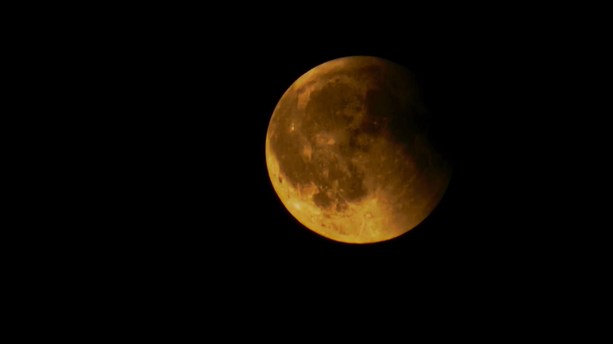 The Moon with shadow on one side is dark yellow in colour. 