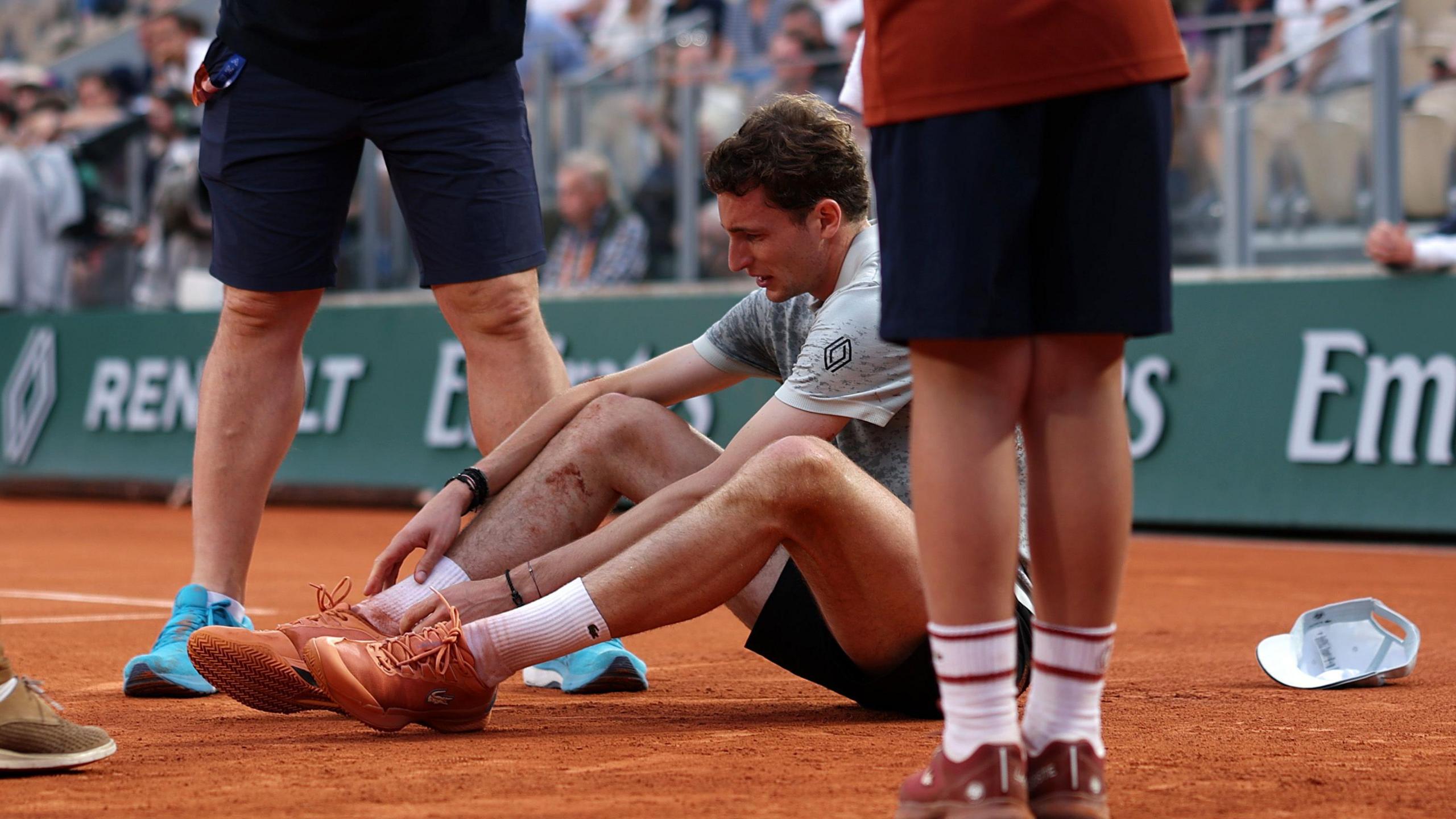 Ugo Humbert sits on the court after falling