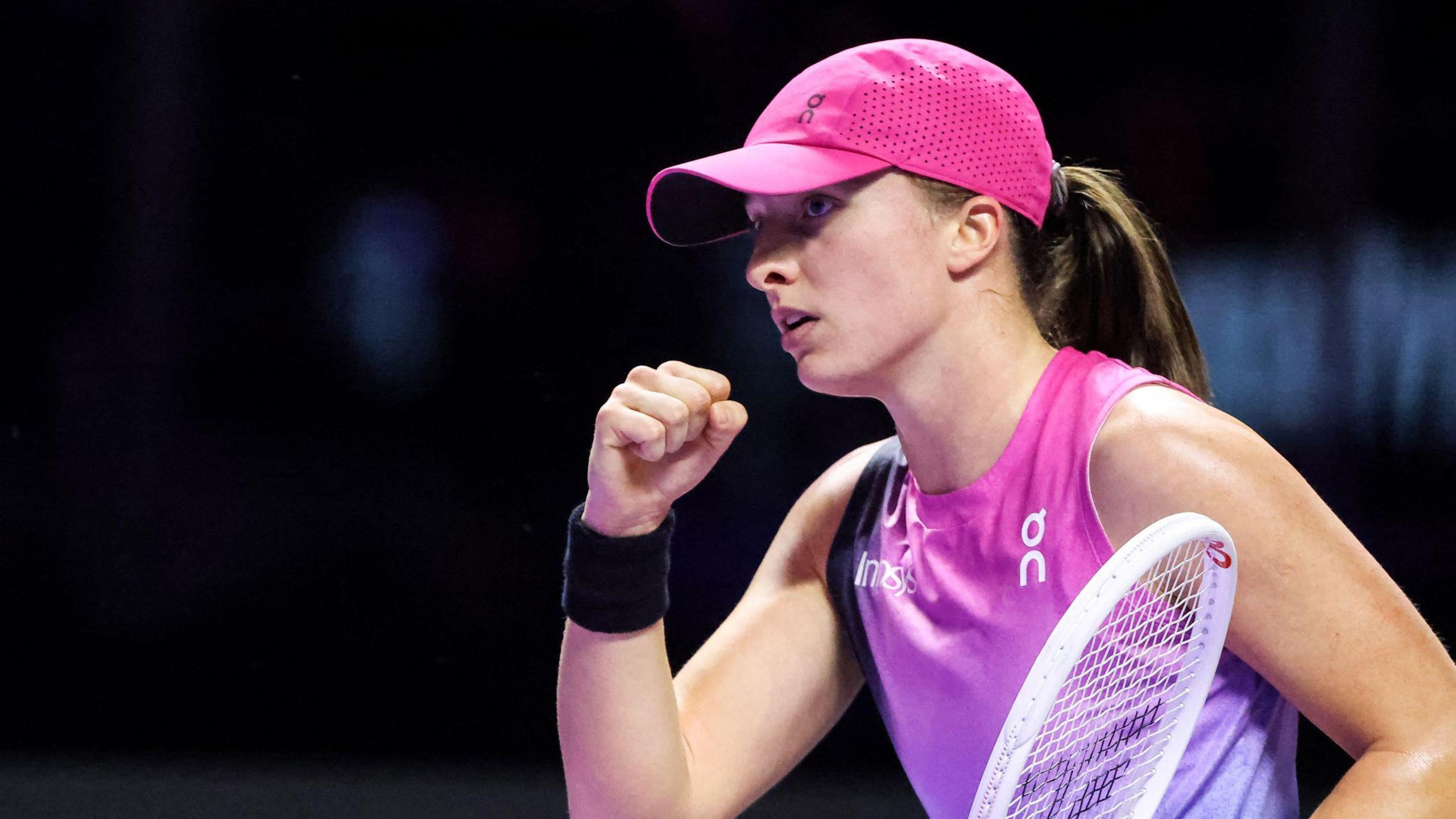 Iga Swiatek clenches her fist in celebration during her WTA Finals win over Daria Kasatkina in Saudi Arabia