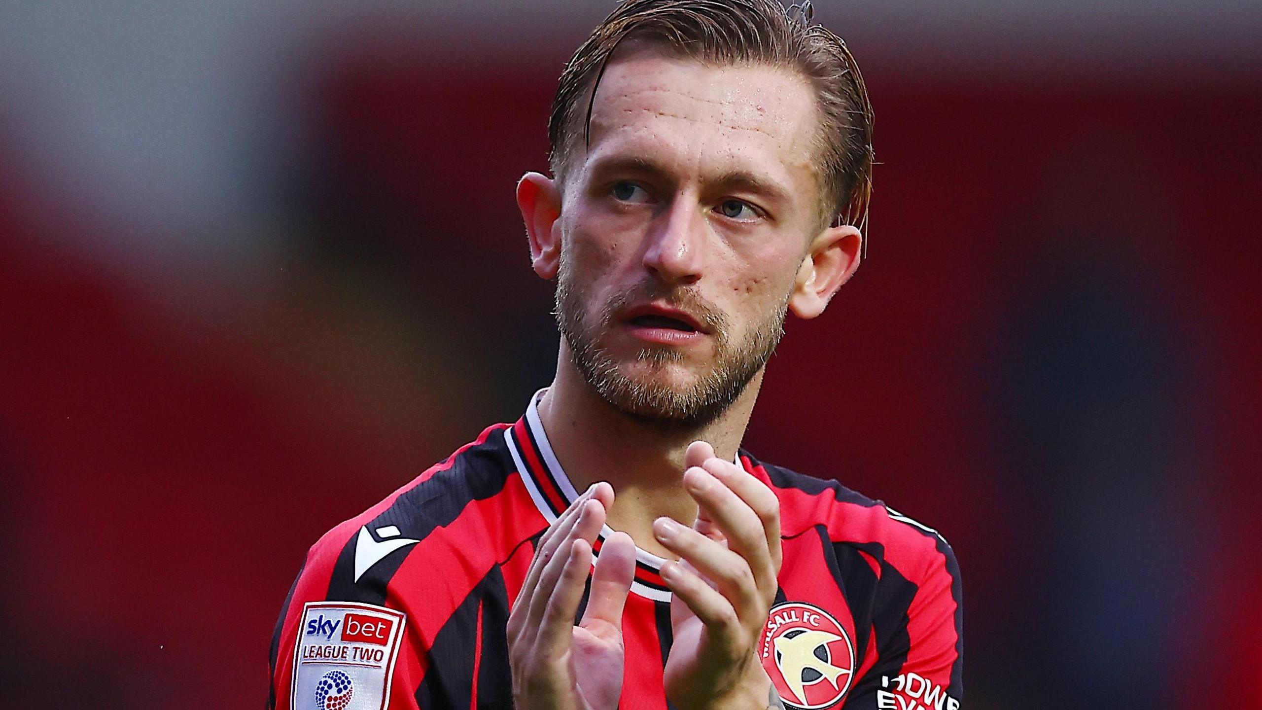 Walsall's Charlie Lakin in action during a game in his red and black striped shirt