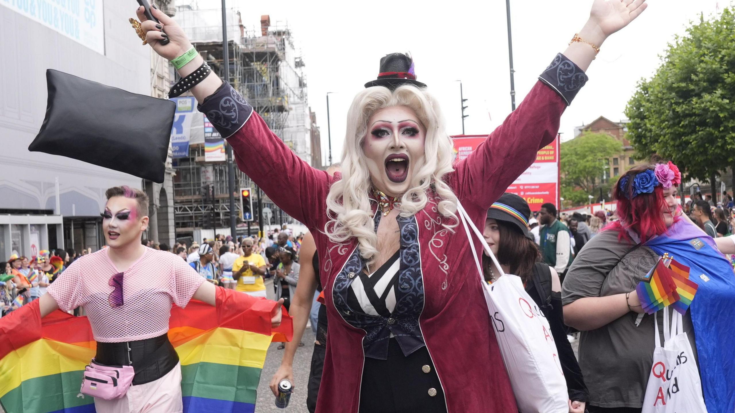 A person wearing drag cheers towards the camera