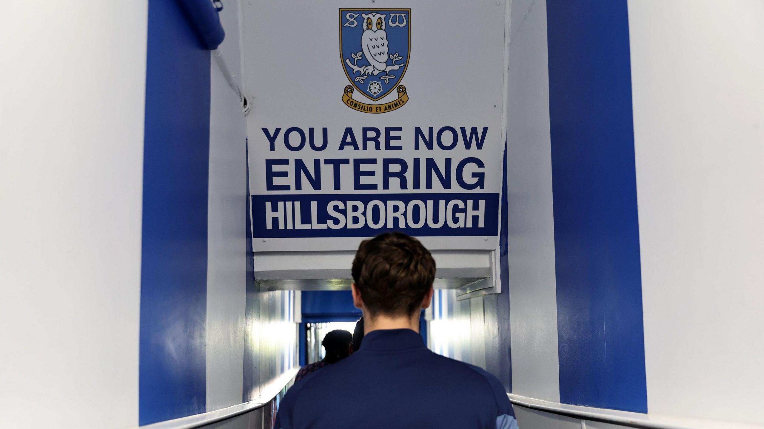 An image of a player walking through a tunnel with a sign above him saying 'You are now entering Hillsborough' with an image of the Sheffield Wednesday club badge