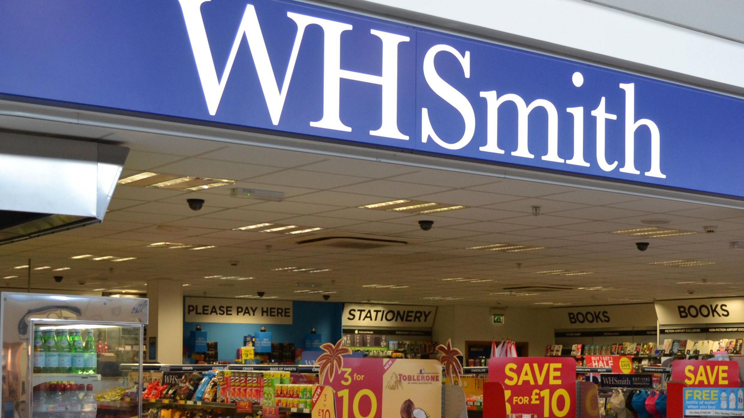 An image of the WHSmith shop front in Jersey airport. You can see the company logo, and below it a range of products.