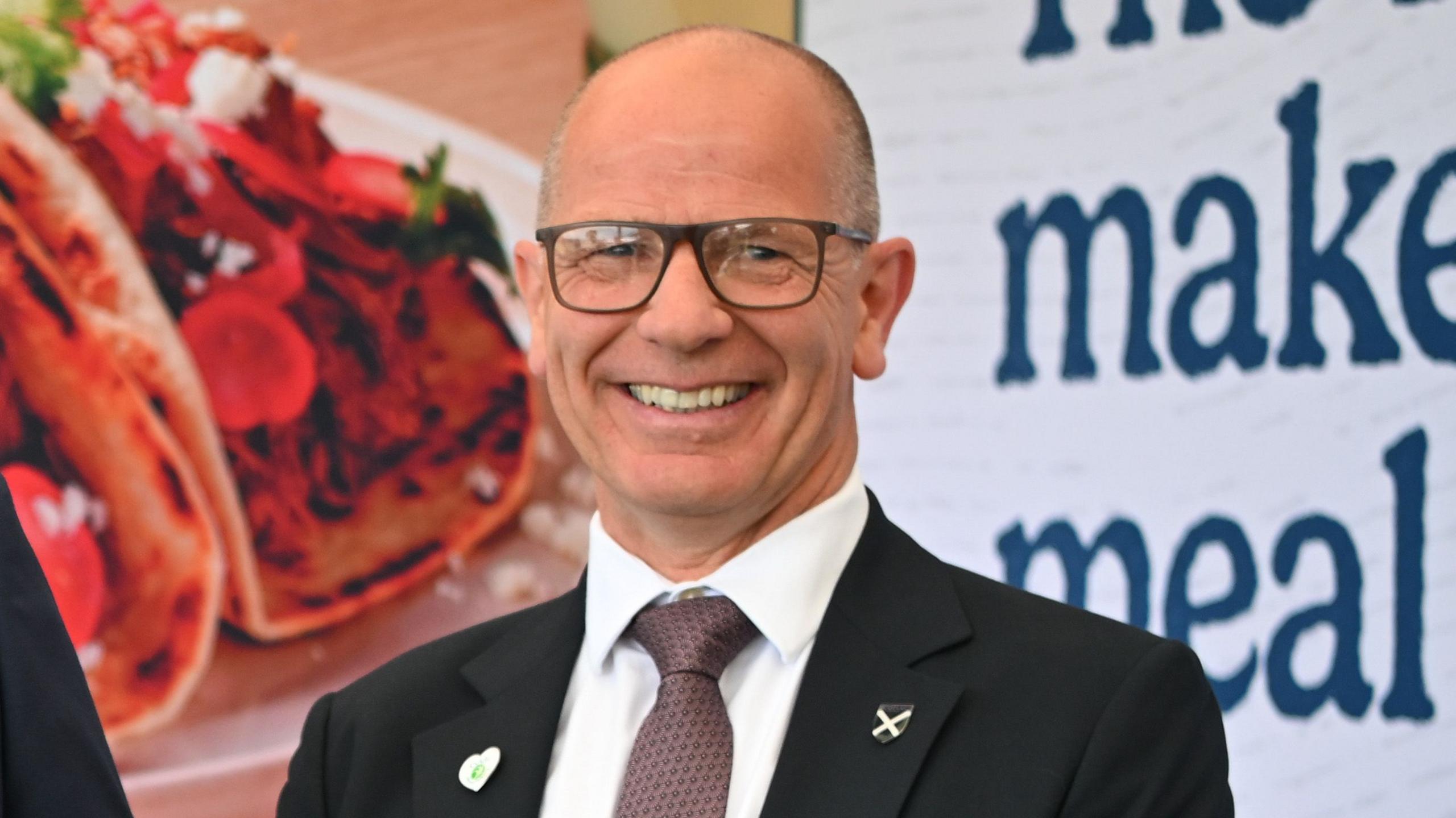 Agriculture Minister Jim Fairlie, a bald-headed man with glasses in a suit and tie with a white shirt