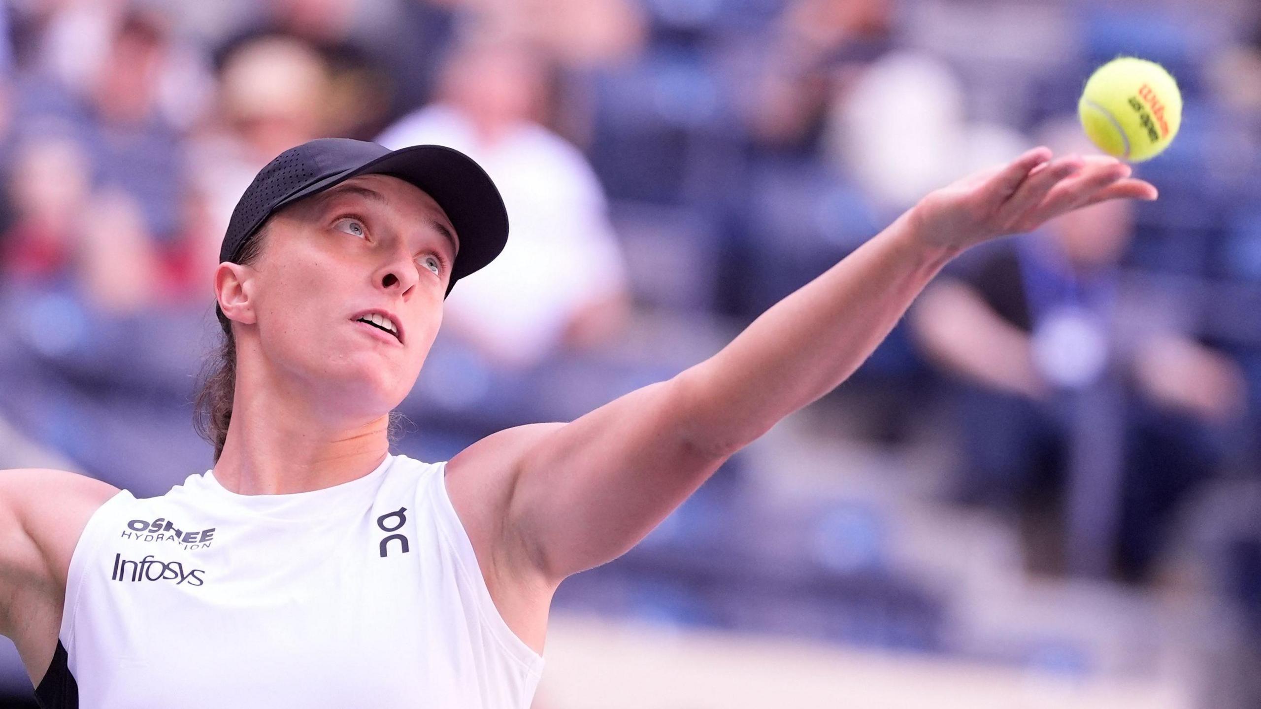 Iga Swiatek serving the ball during her first-round match at the US Open on Arthur Ashe Stadium