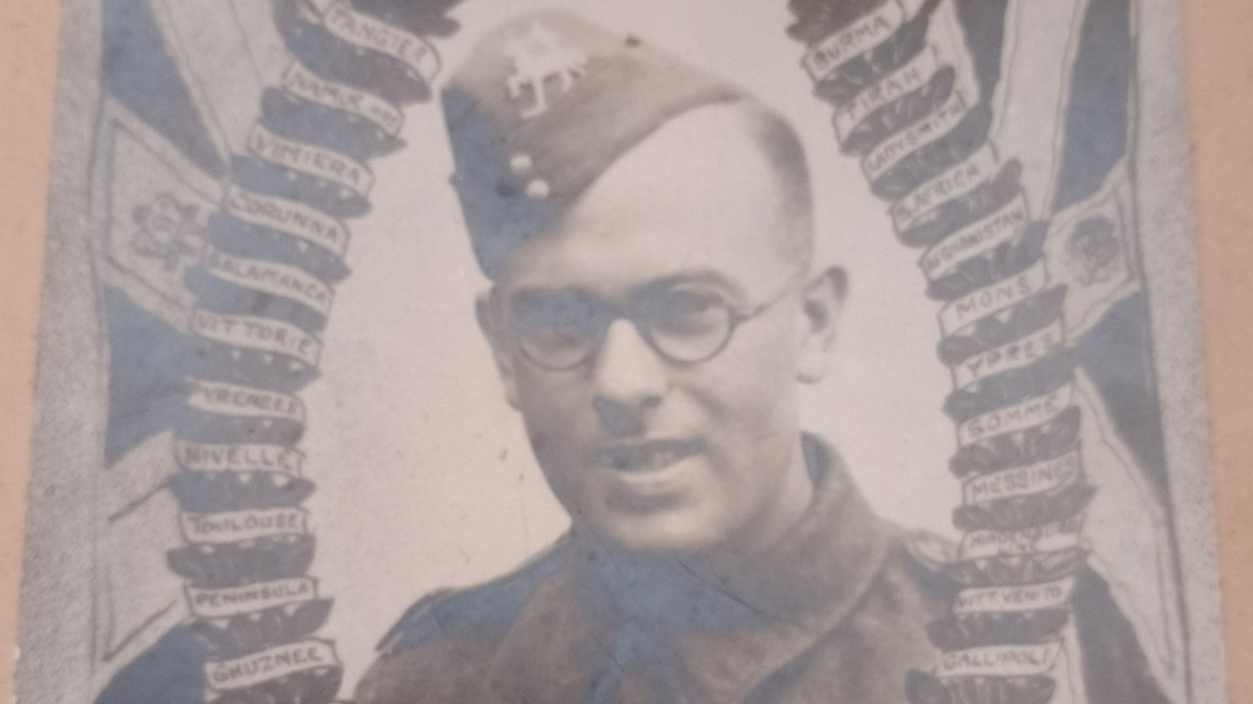 A young man in army uniform with round glasses in a faded official army photo.