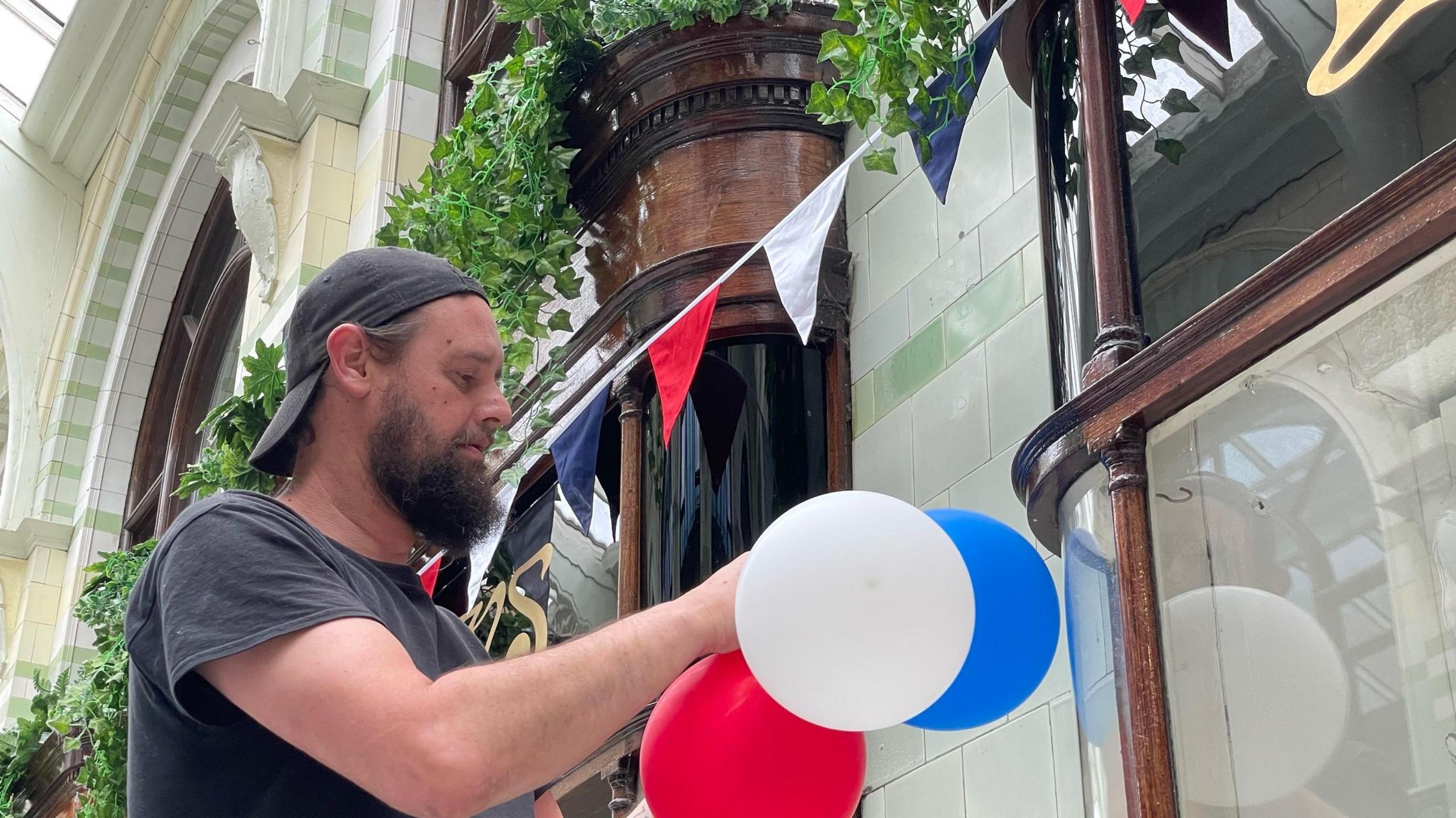 Man hanging balloons in arcade