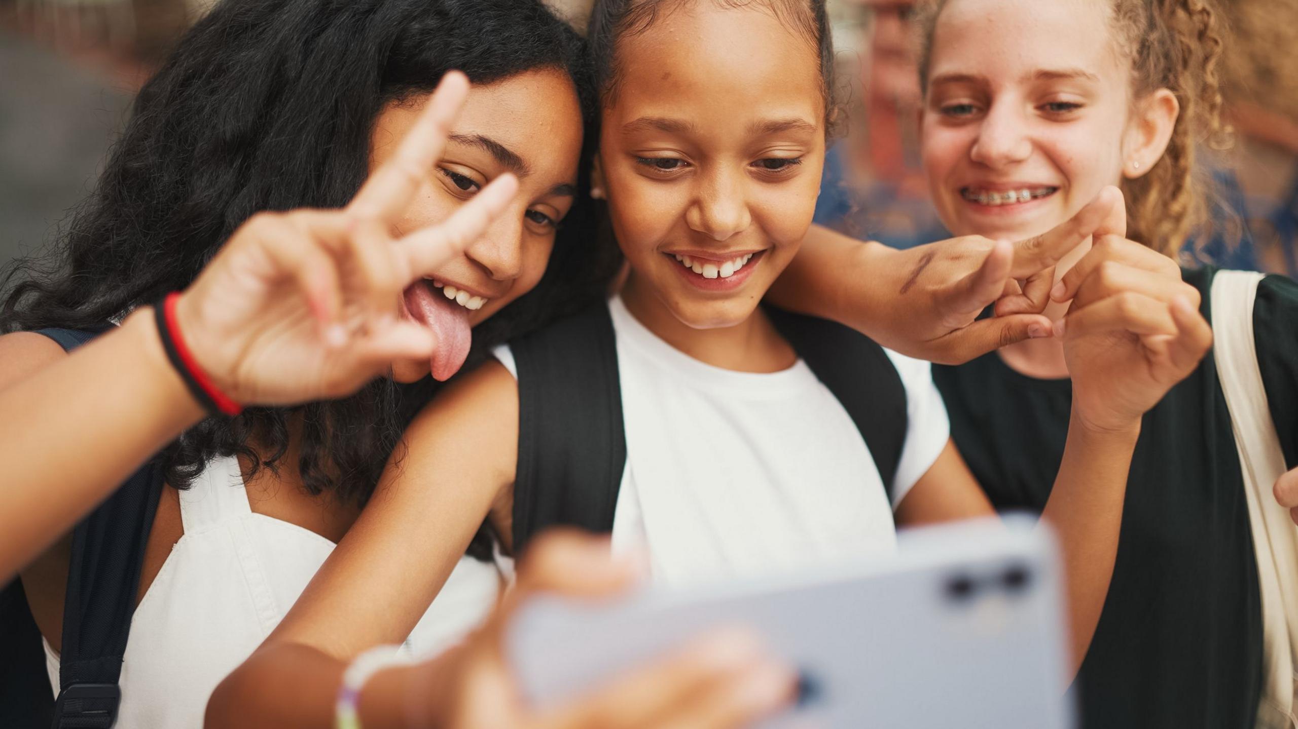 three girls taking a selfie. 