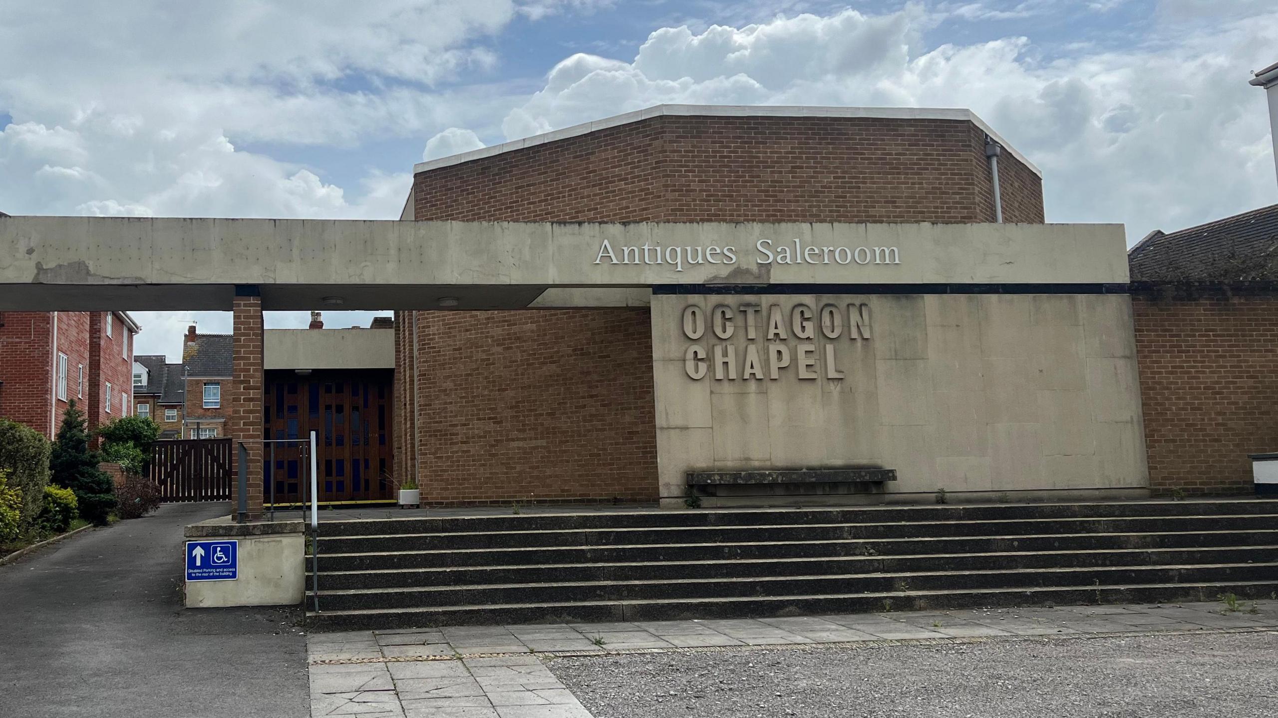 The front of the Octagon Chapel with its name and above that a sign saying Antiques Saleroom