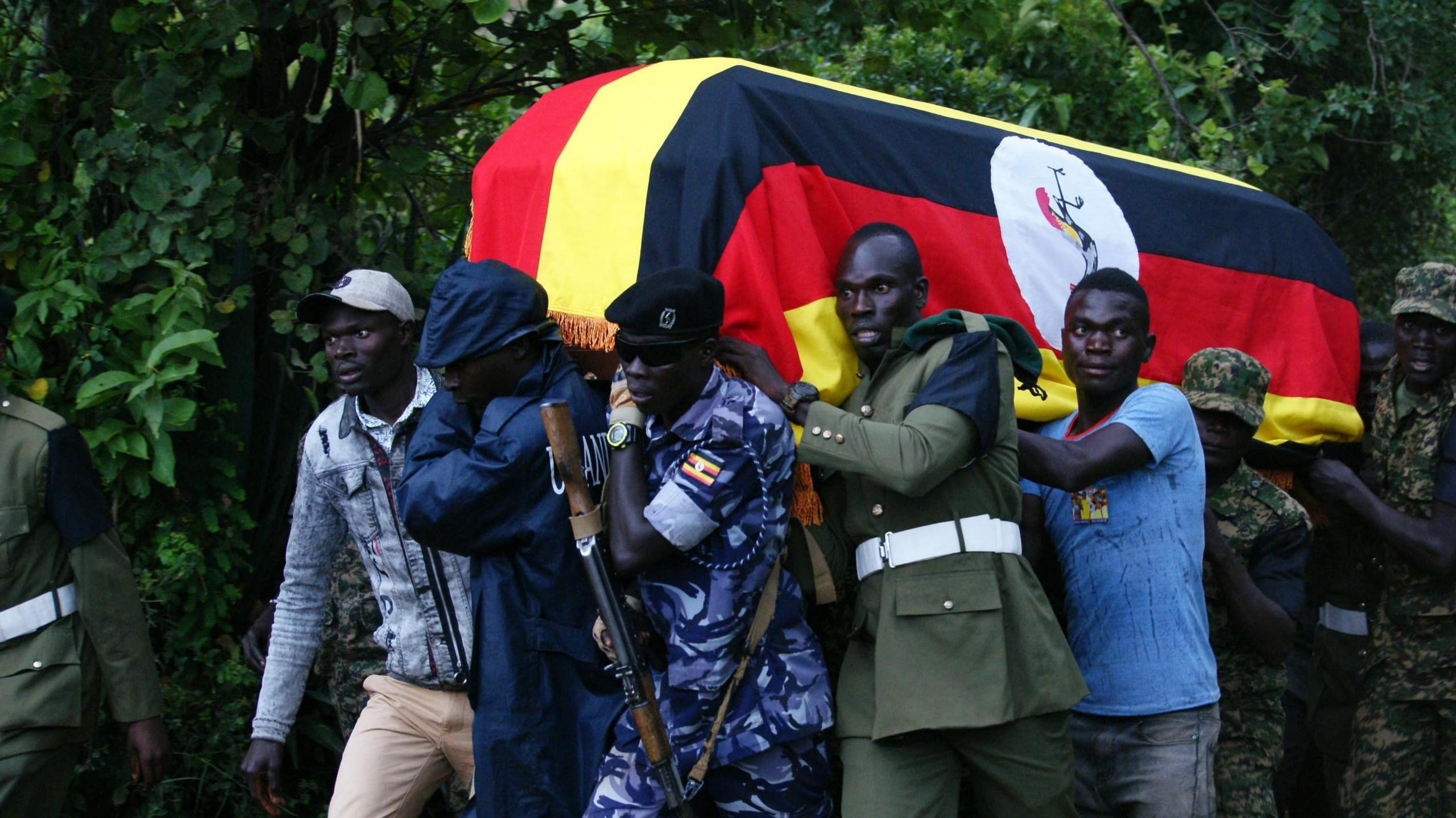 Soldiers carrying a coffin draped in the Ugandan flag