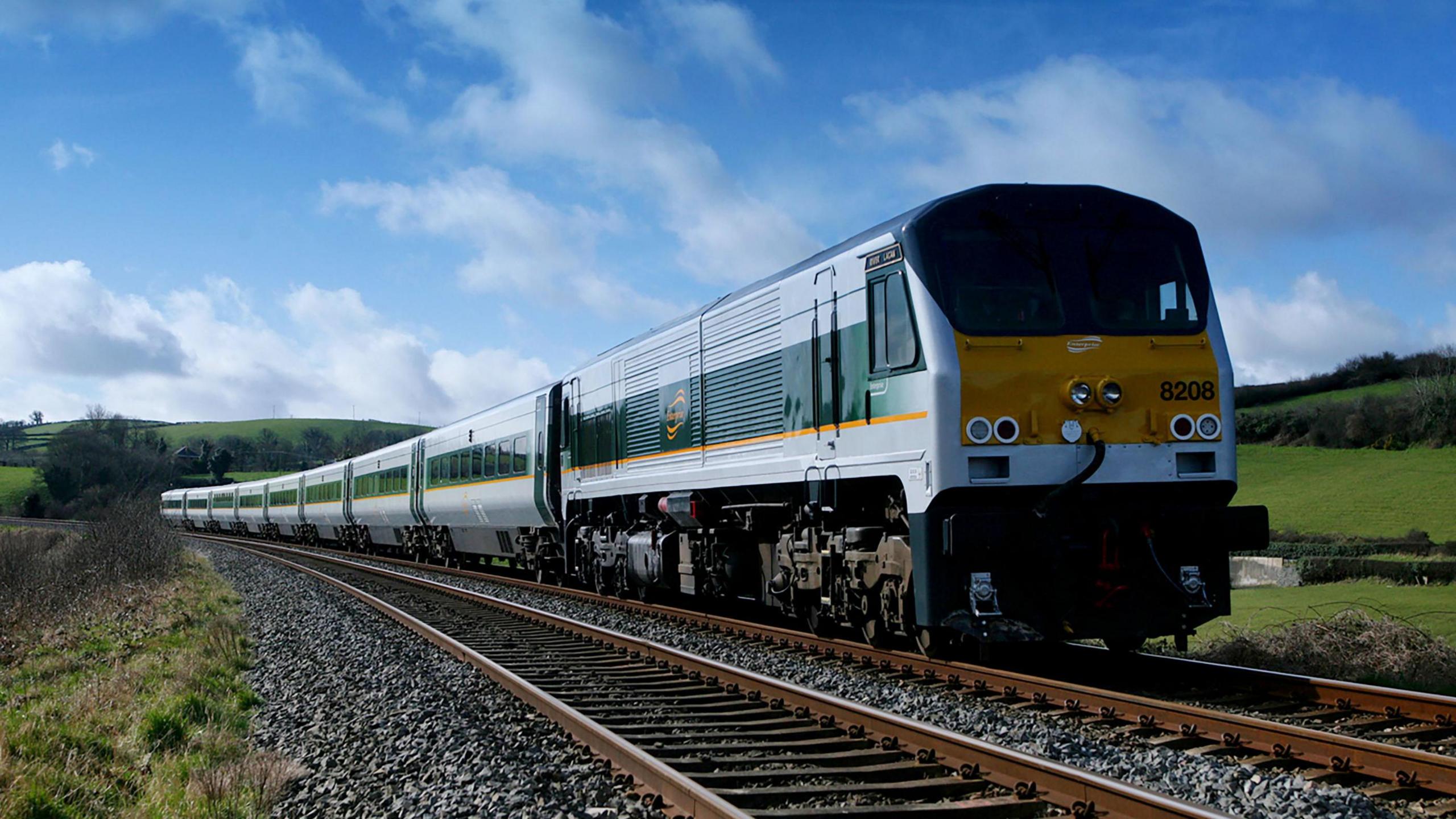 The enterprise train, in grey, green and gold paint, travels towards the camera