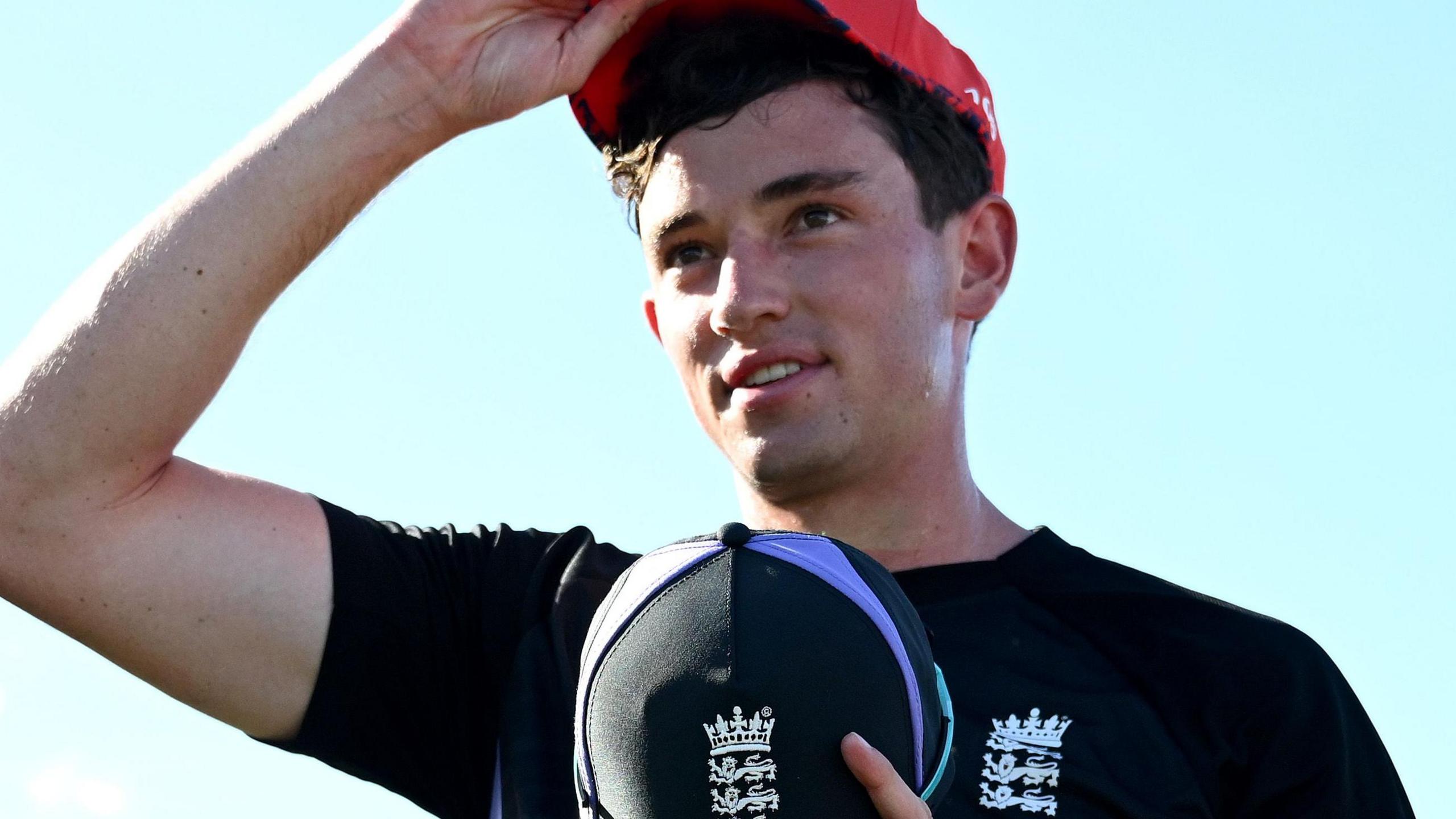 John Turner wearing a blue England top and holding a blue England cap