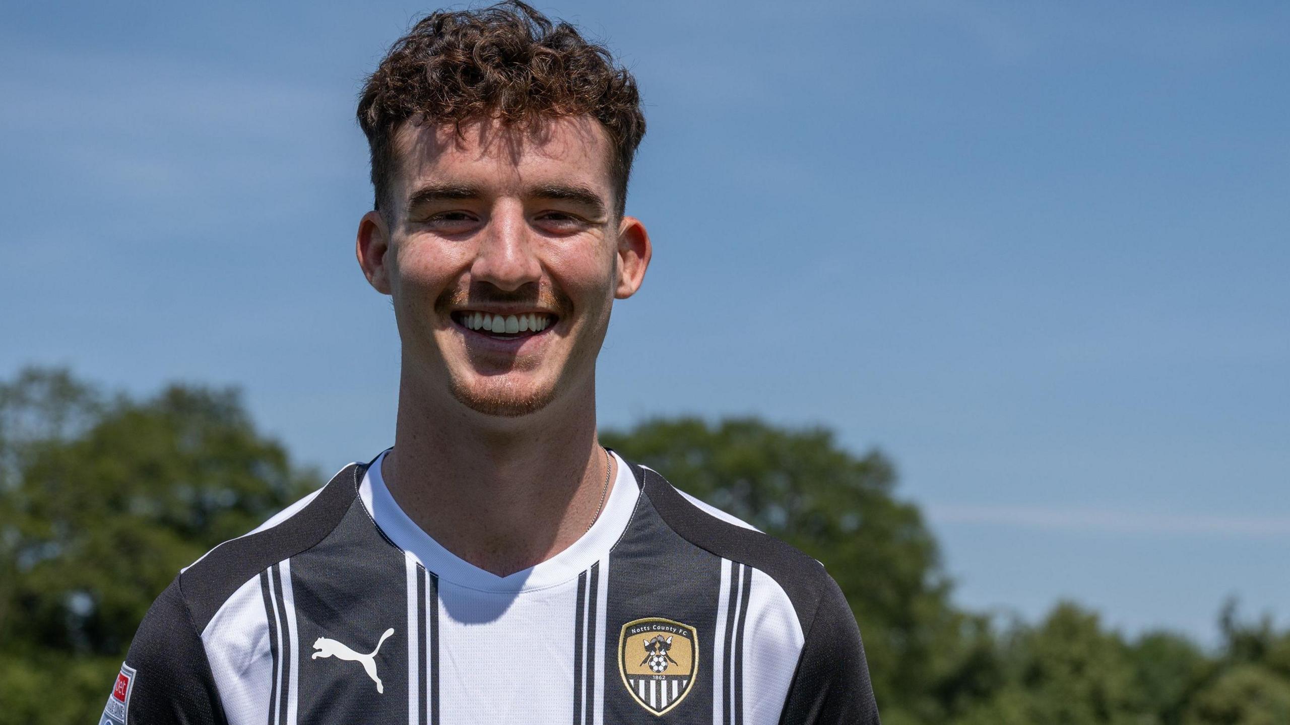 Luka Smyth poses for a picture in Notts County colours after joining the League One side