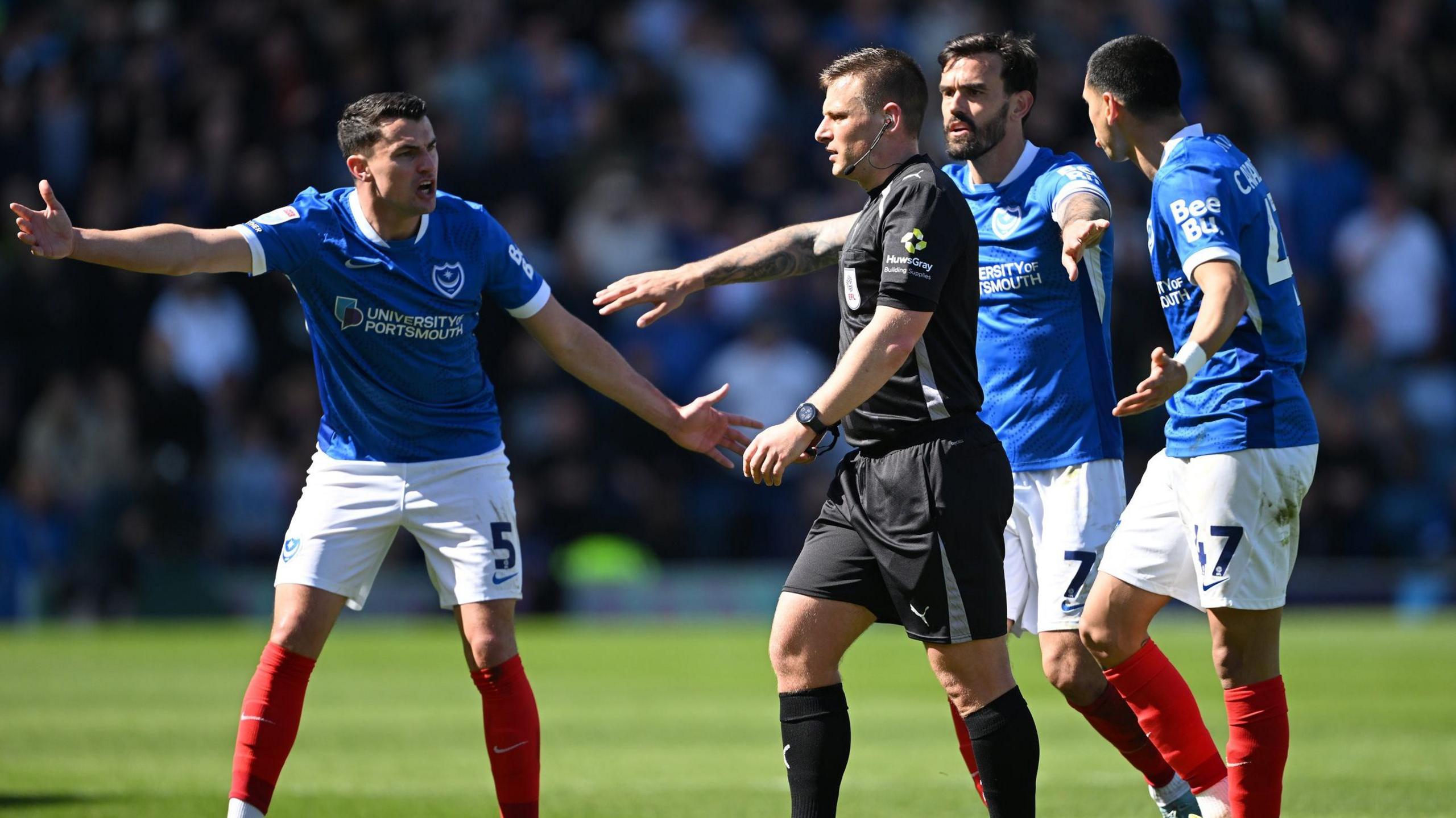 Portsmouth players appeal to the referee during their match with Oxford United