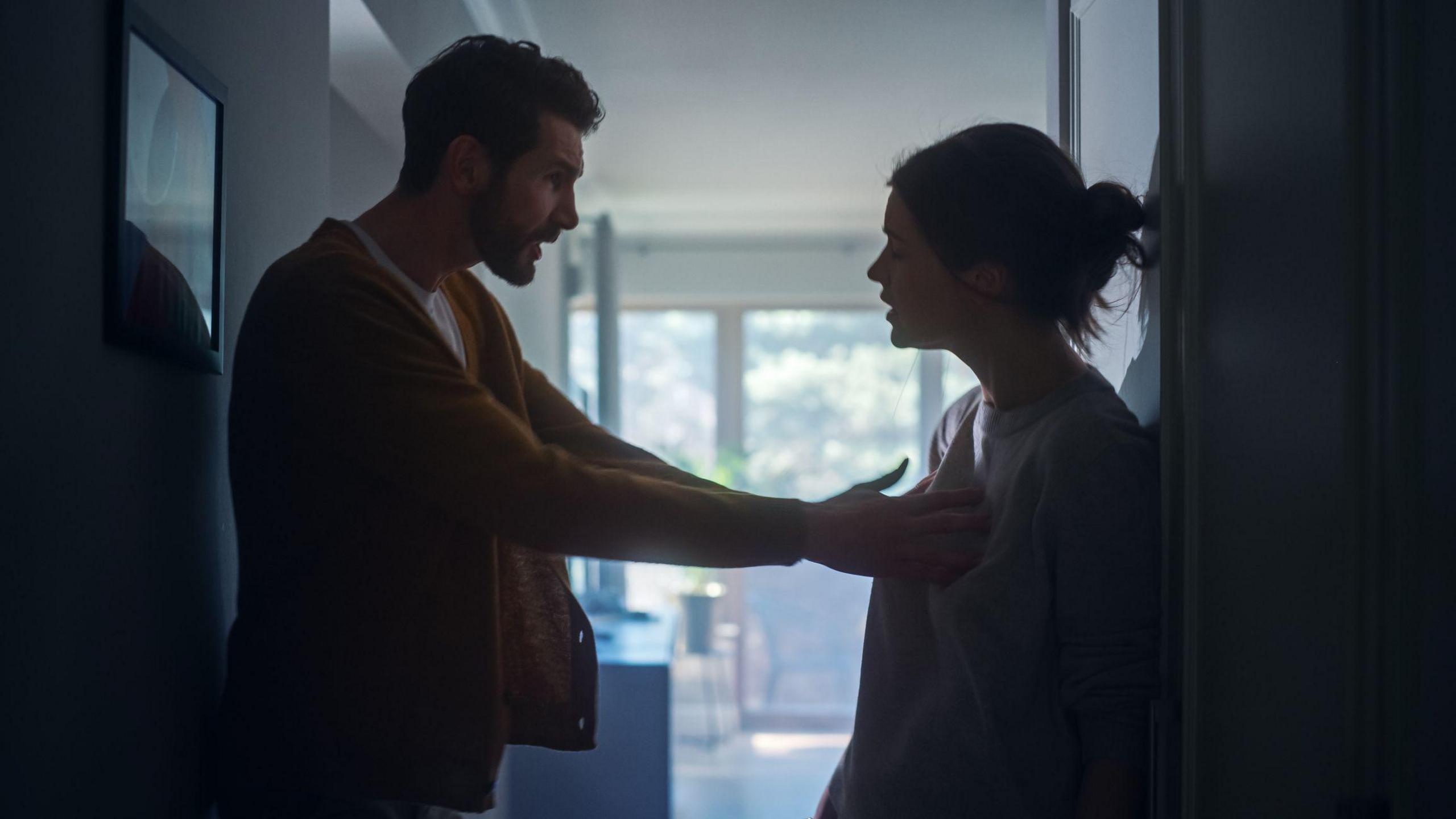 A silhouetted man and woman in an argument 