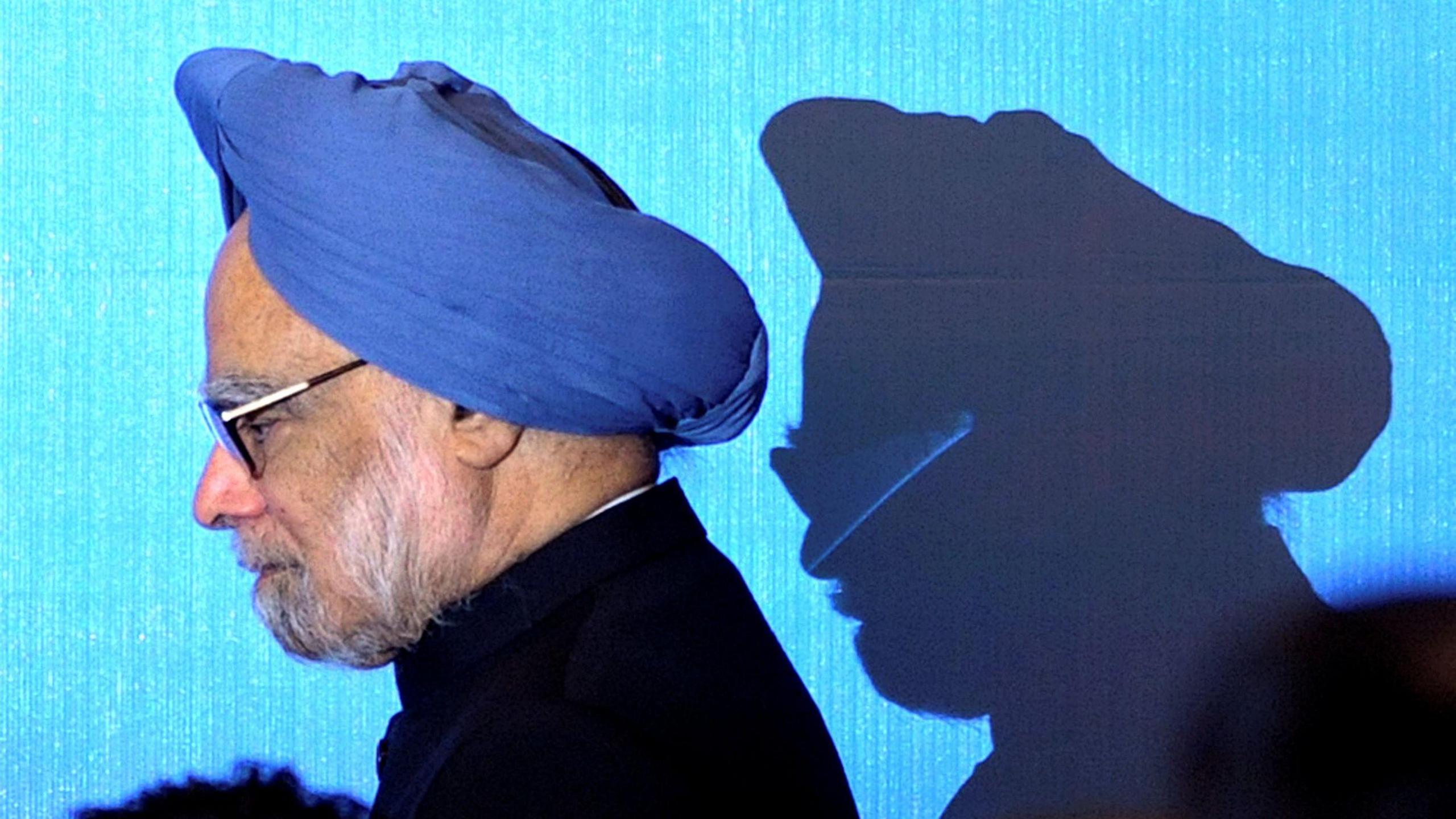 India's Prime Minister Manmohan Singh wearing a black suit and a blue turban walks on stage for a photo opportunity as part of the 5th East Asia Summit in Hanoi, Vietnam, October 30, 2010. 