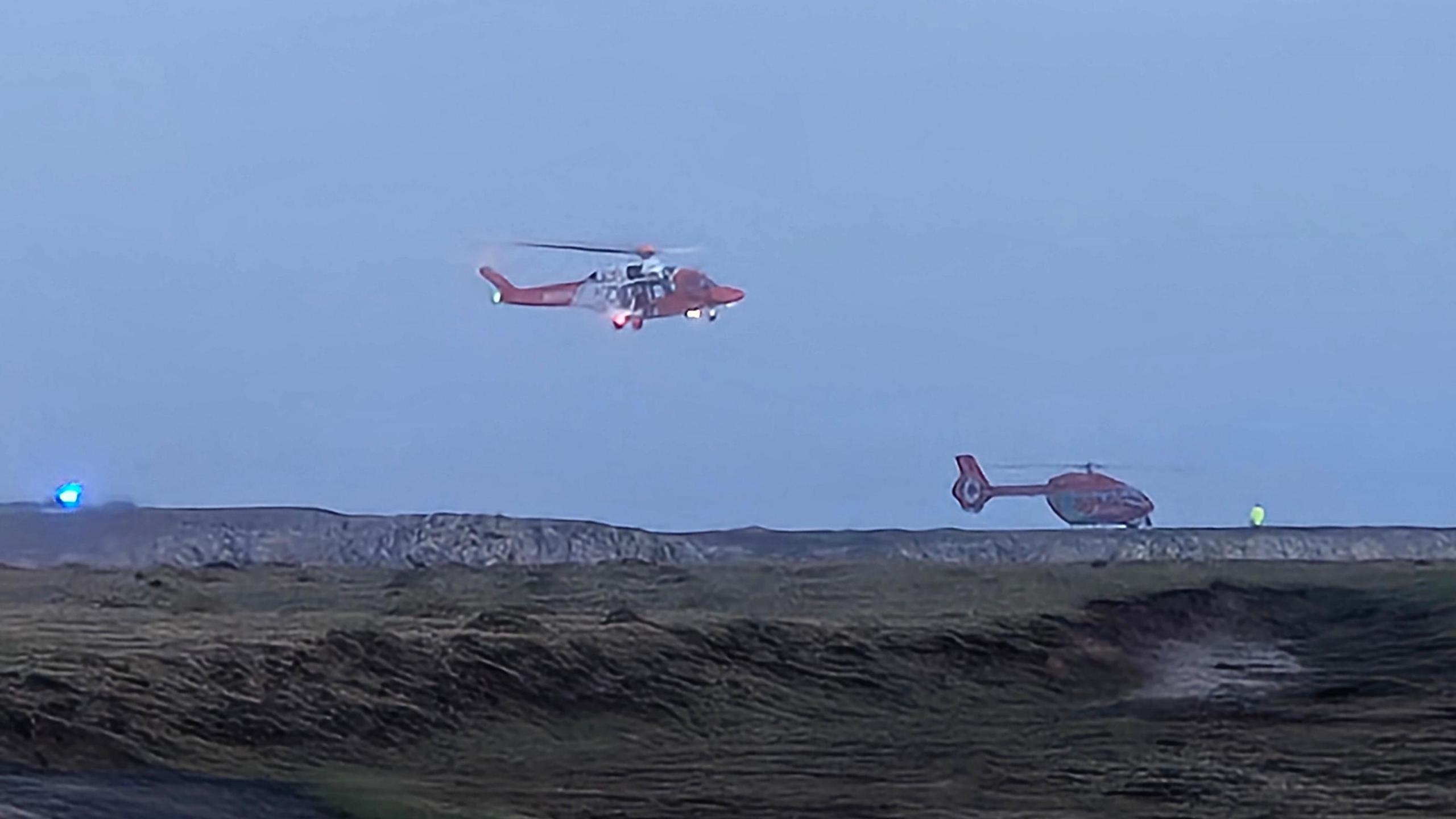 Llun o ddau hofrennydd sy'n chwilio am y tri dringwr yn Gofan, Sir Benfro