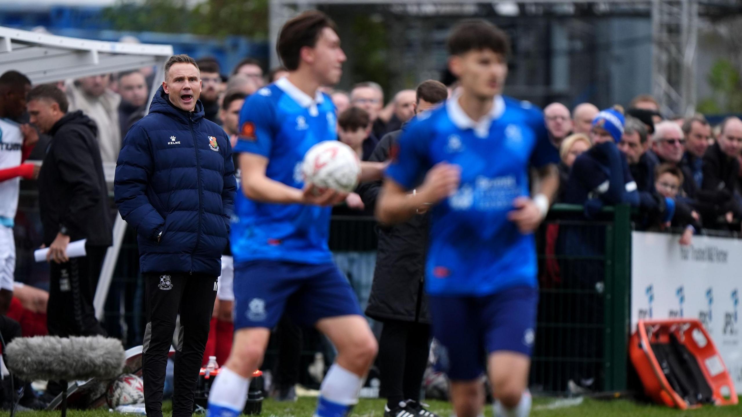 Wealdstone manager Matt Taylor on the touchline during the Emirates FA Cup second round match at the Grosvenor Vale, Ruislip, with two players in view.