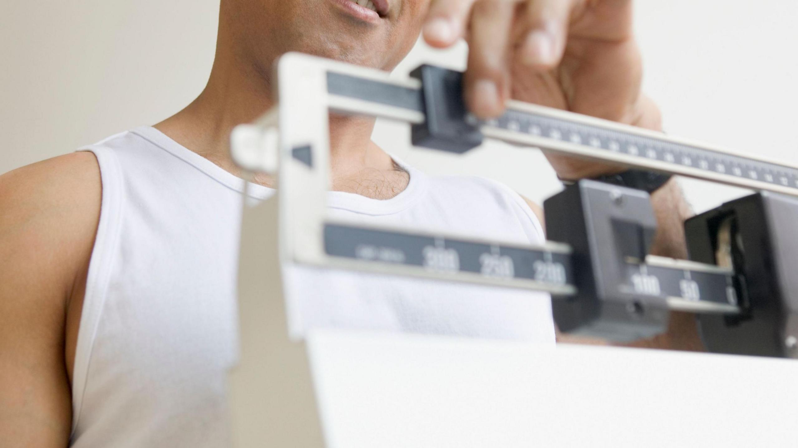 Generic image of a man standing on scales