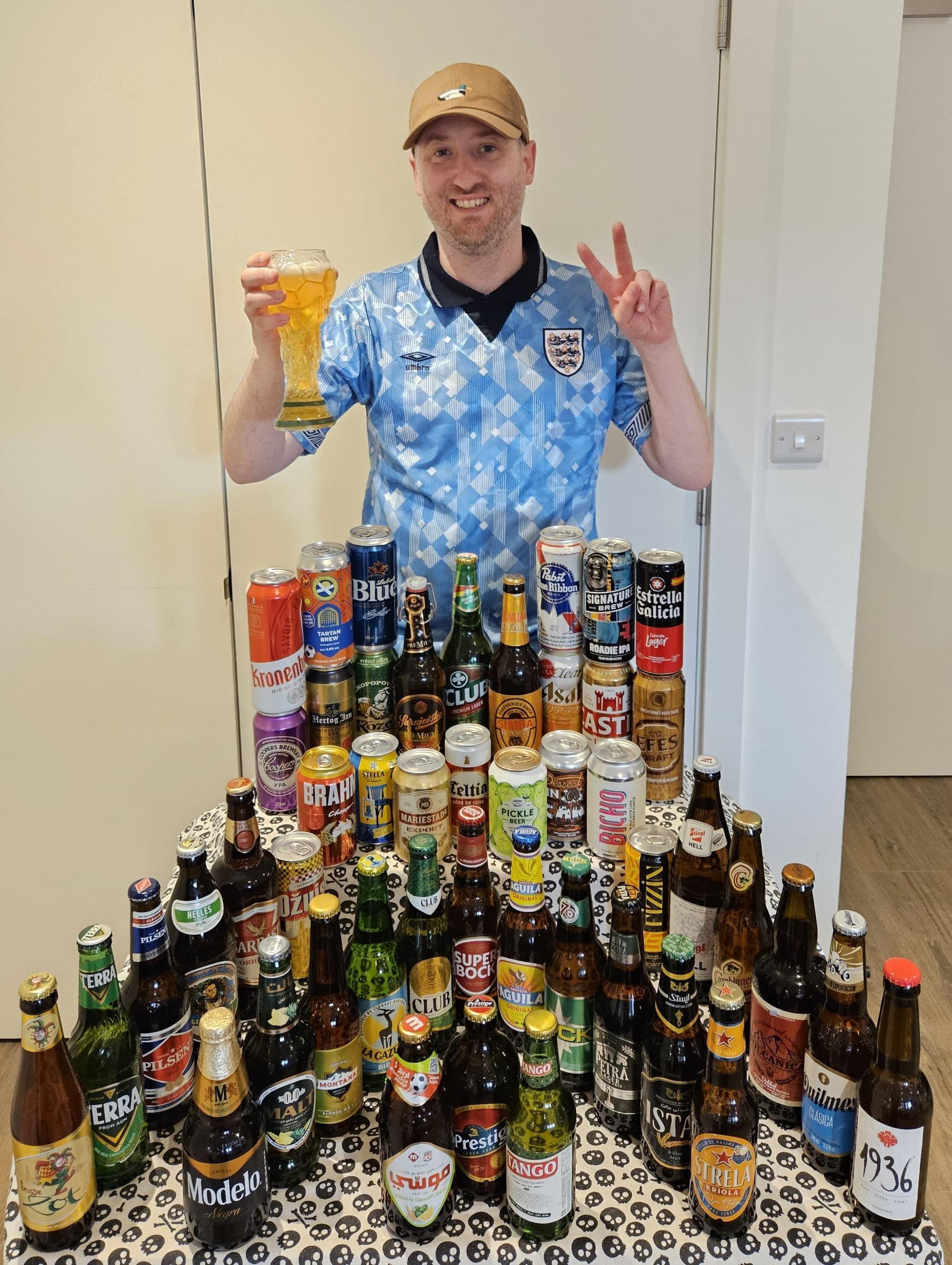 Gus Hully poses with beers from all 48 nations competing at World Cup 2026