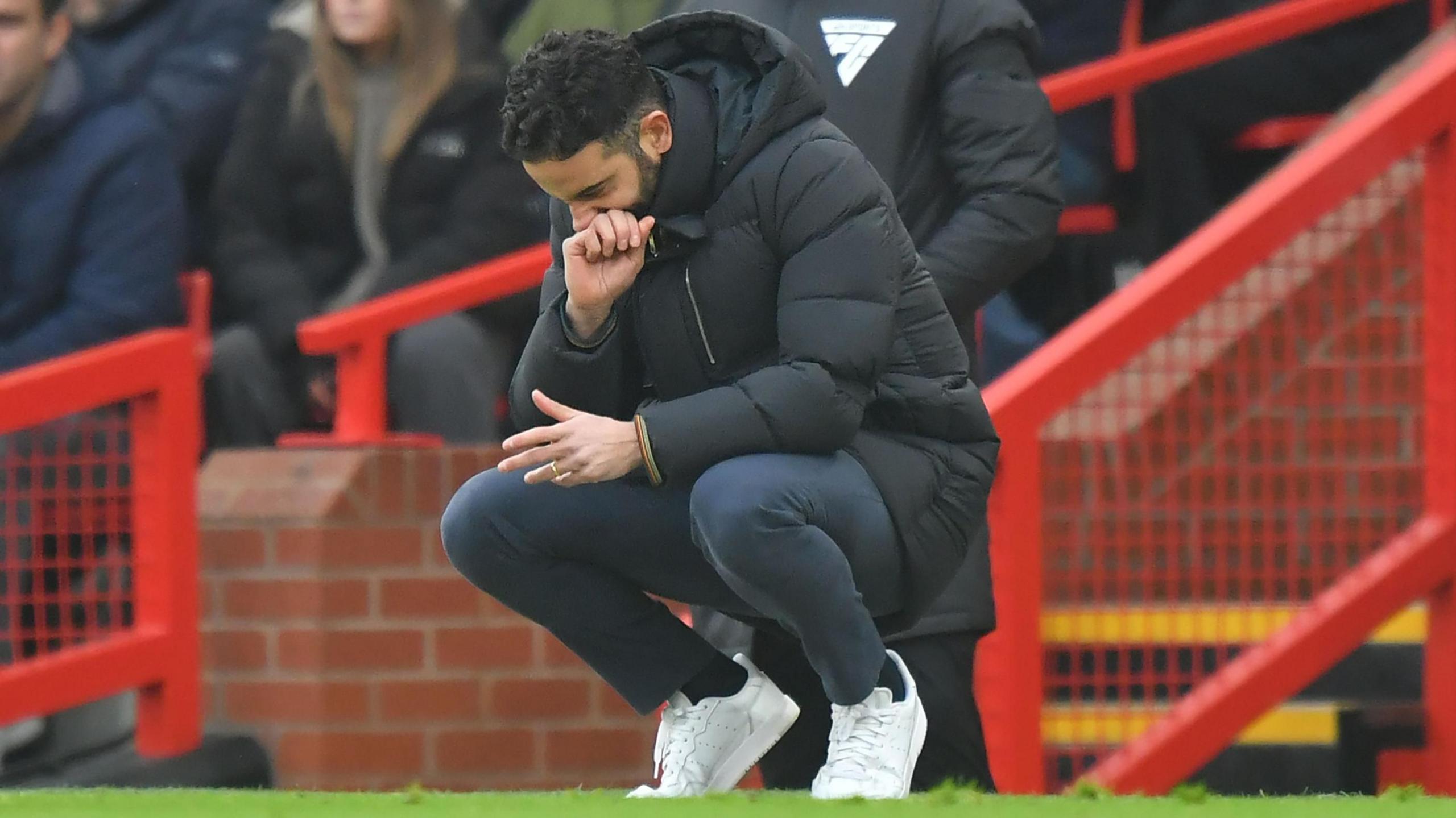 Ruben Amorim on his haunches looking down during Man Utd's defeat to Brighton