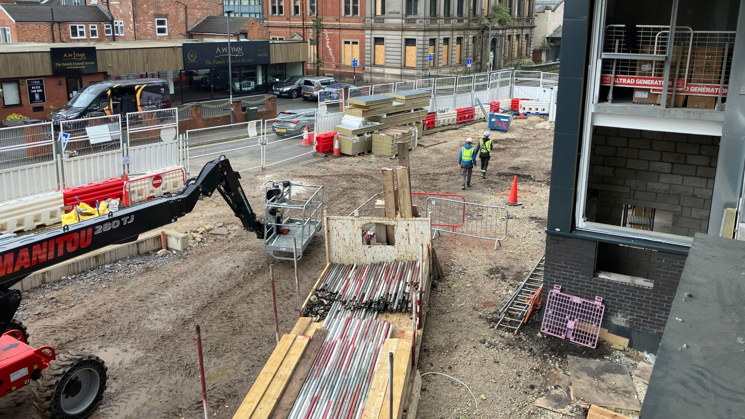 Construction workers and vehicles outside the Arena