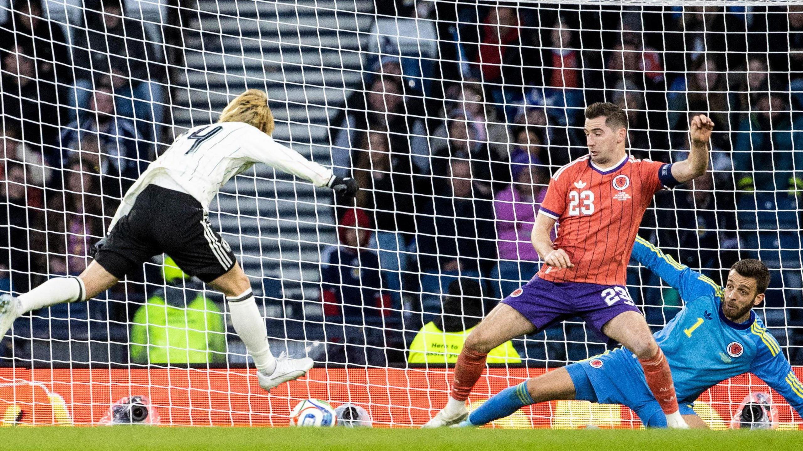 Junya Ito scores for Japan as Scott McKenna and Angus Gunn watch on