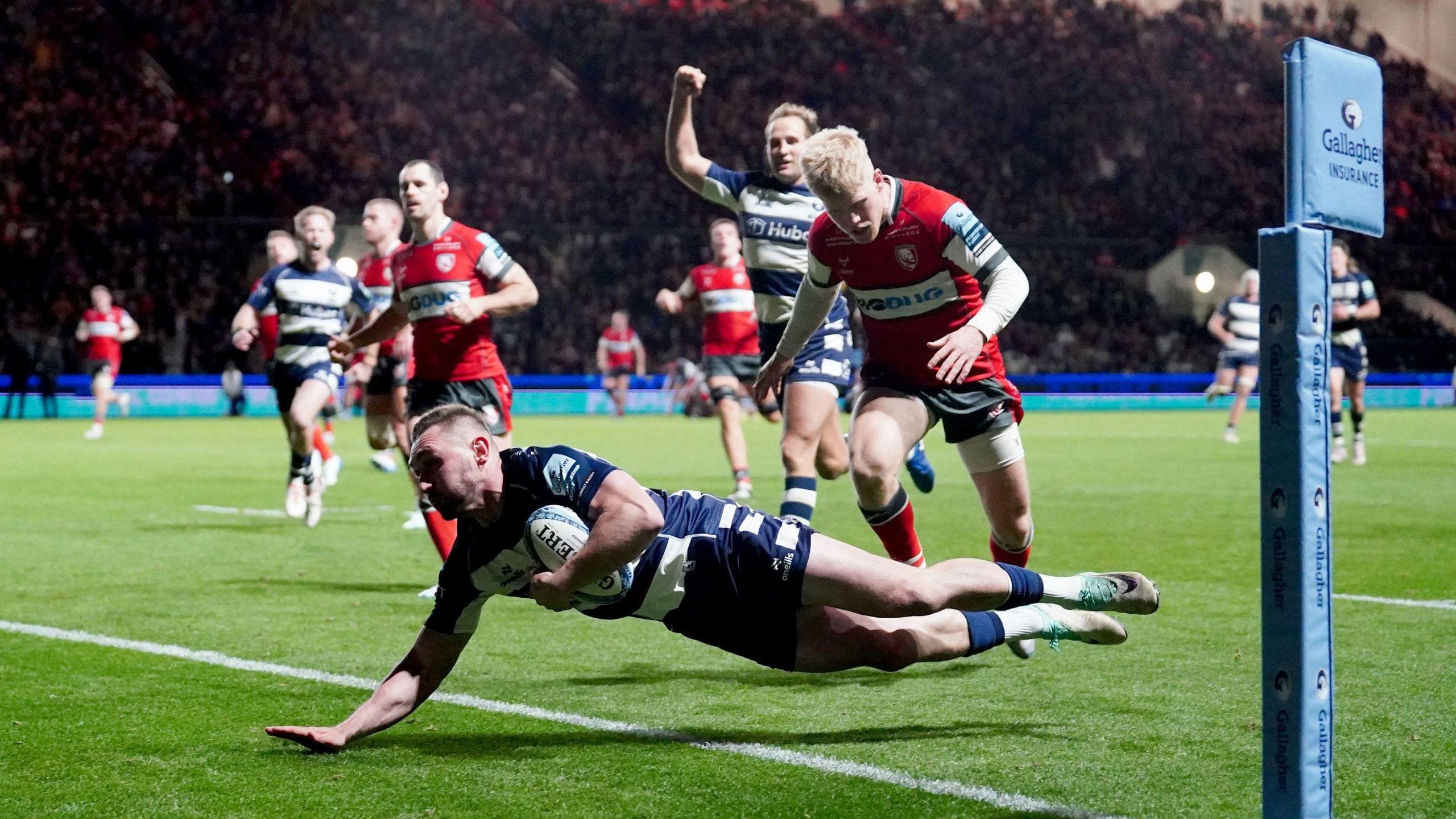 Bristol's Richard Lane dives over the line to score a try as Bristol Bears host Gloucester at Ashton Gate on Friday night. In the background one of his team-mates begins celebrating while two Gloucester players look on 