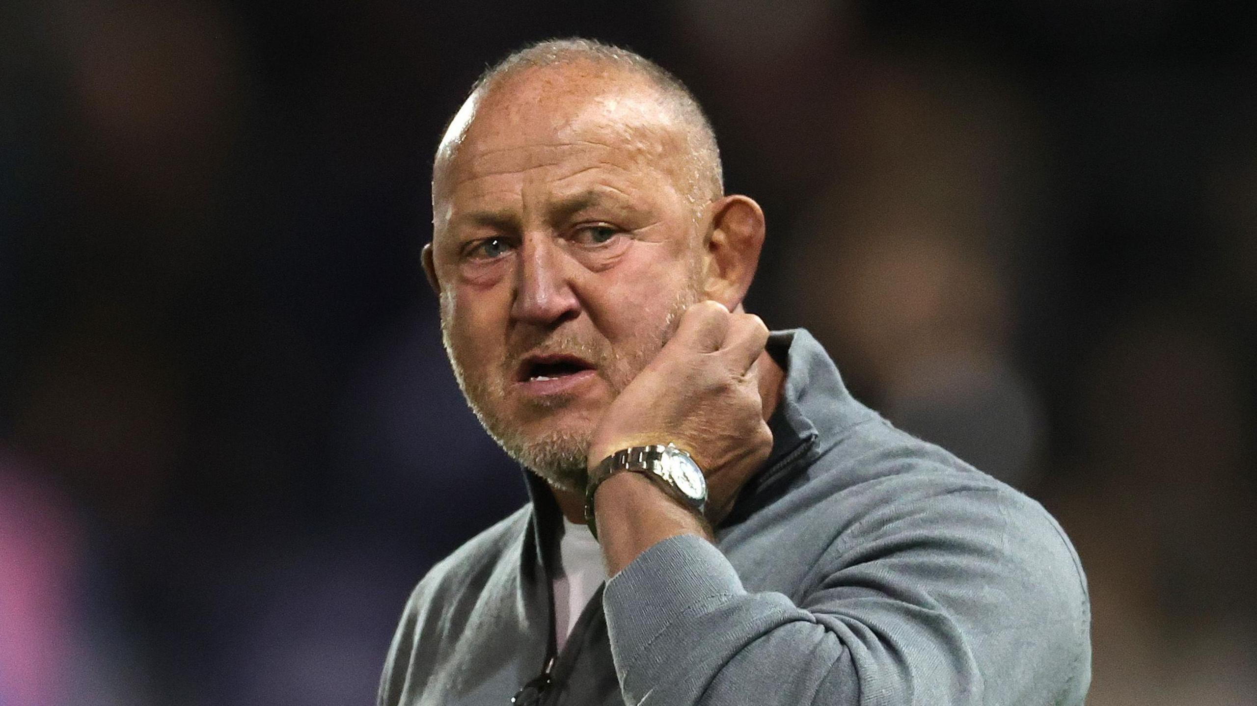 Steve Diamond scratching his cheek with his left hand on the sidelines during a Newcastle match