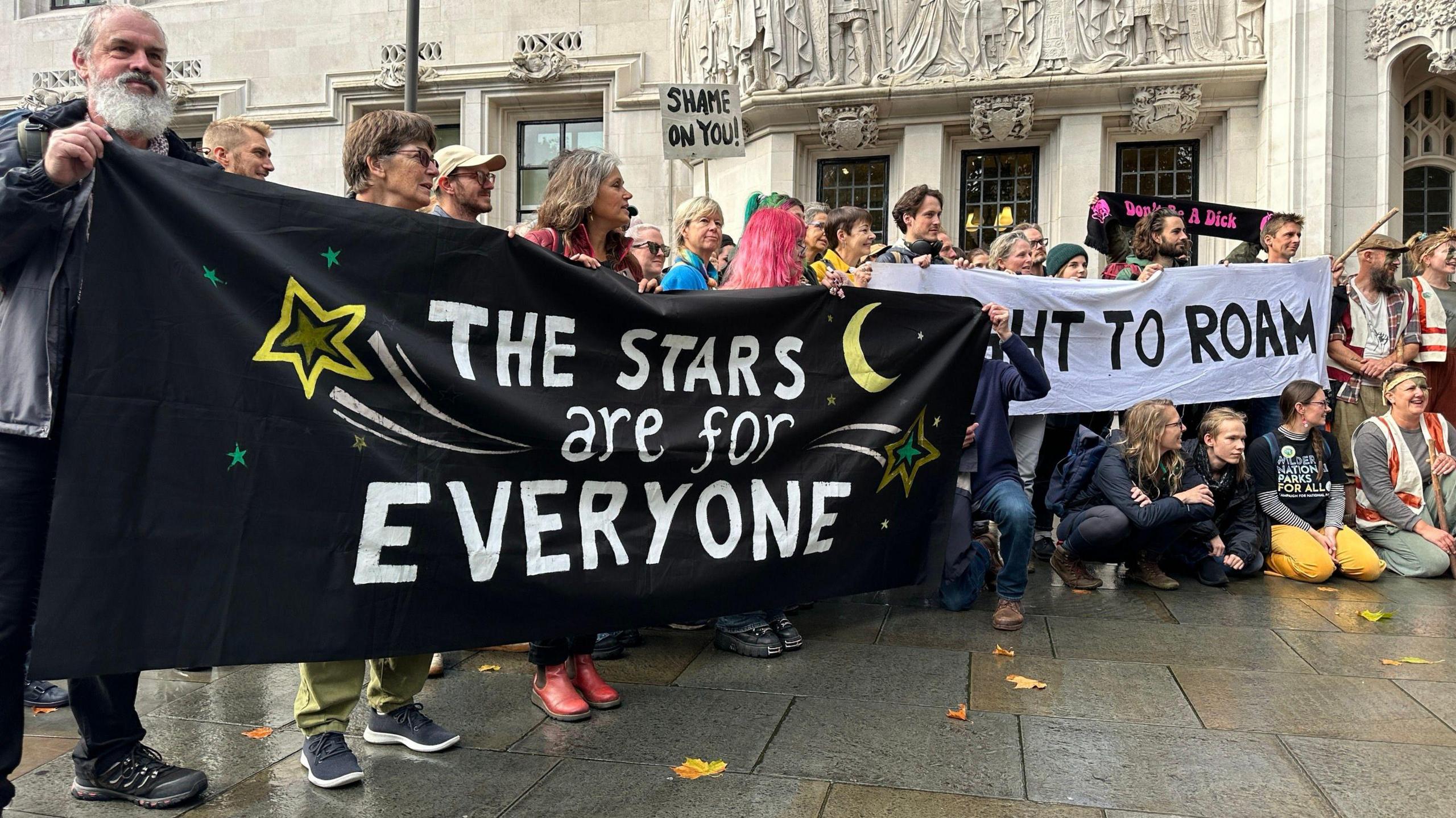 Campaigners for wild camping hold a banner saying the Stars are for Everyone and Right to Roam and Shame on You outside the Supreme Court in London.