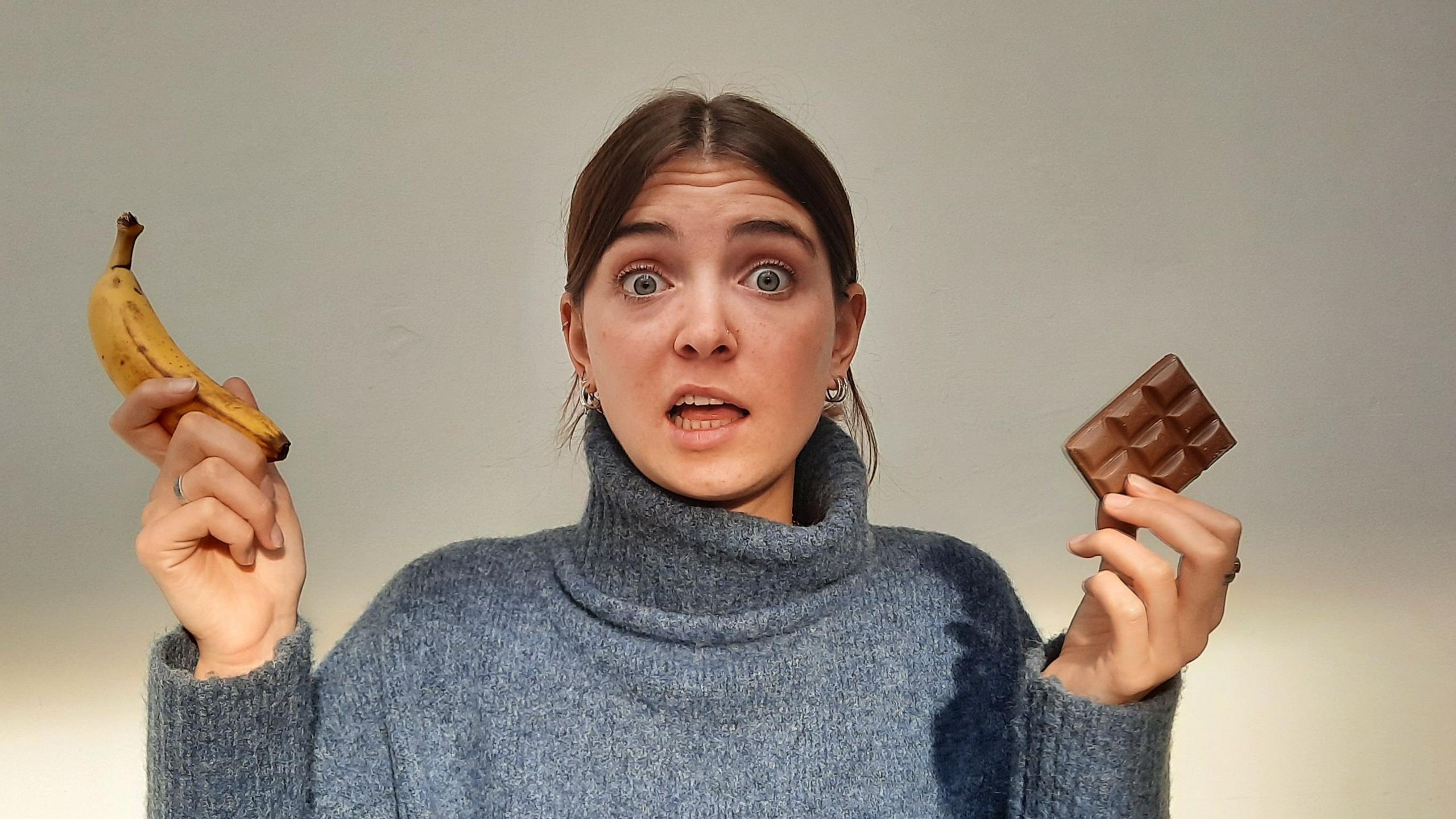 Author, Lottie Savage, holding a banana and pieces of chocolate