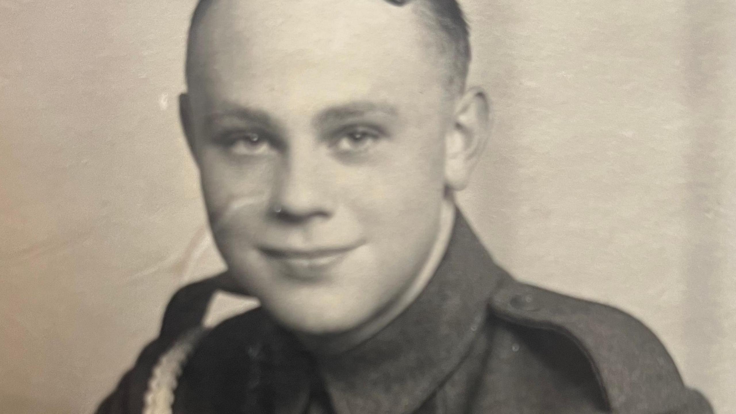Black and white photo of Stanley Eastgate he has short dark hair combed over the top of his head and is wearing an army uniform with high collar.