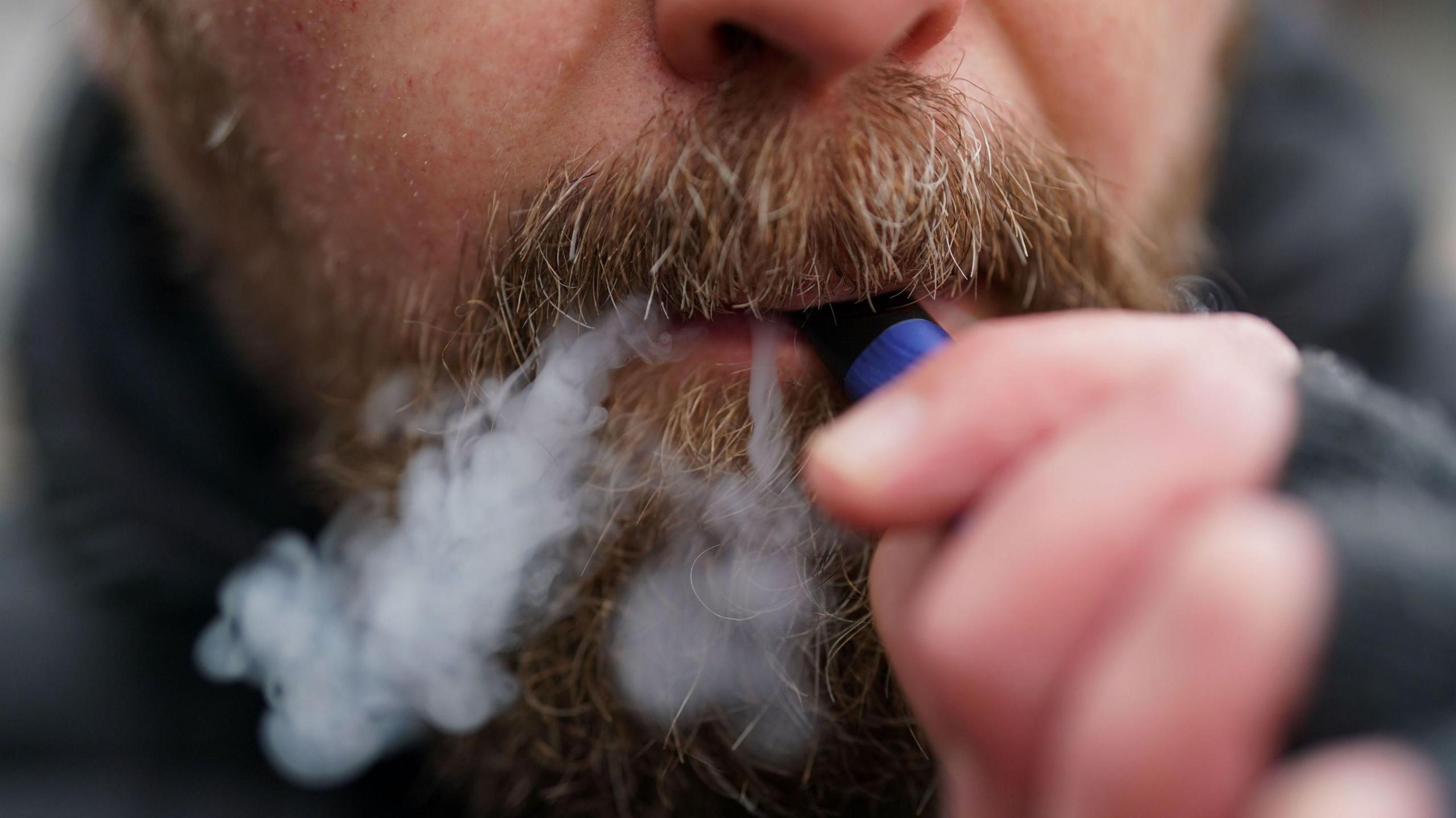 A man using a disposable vape